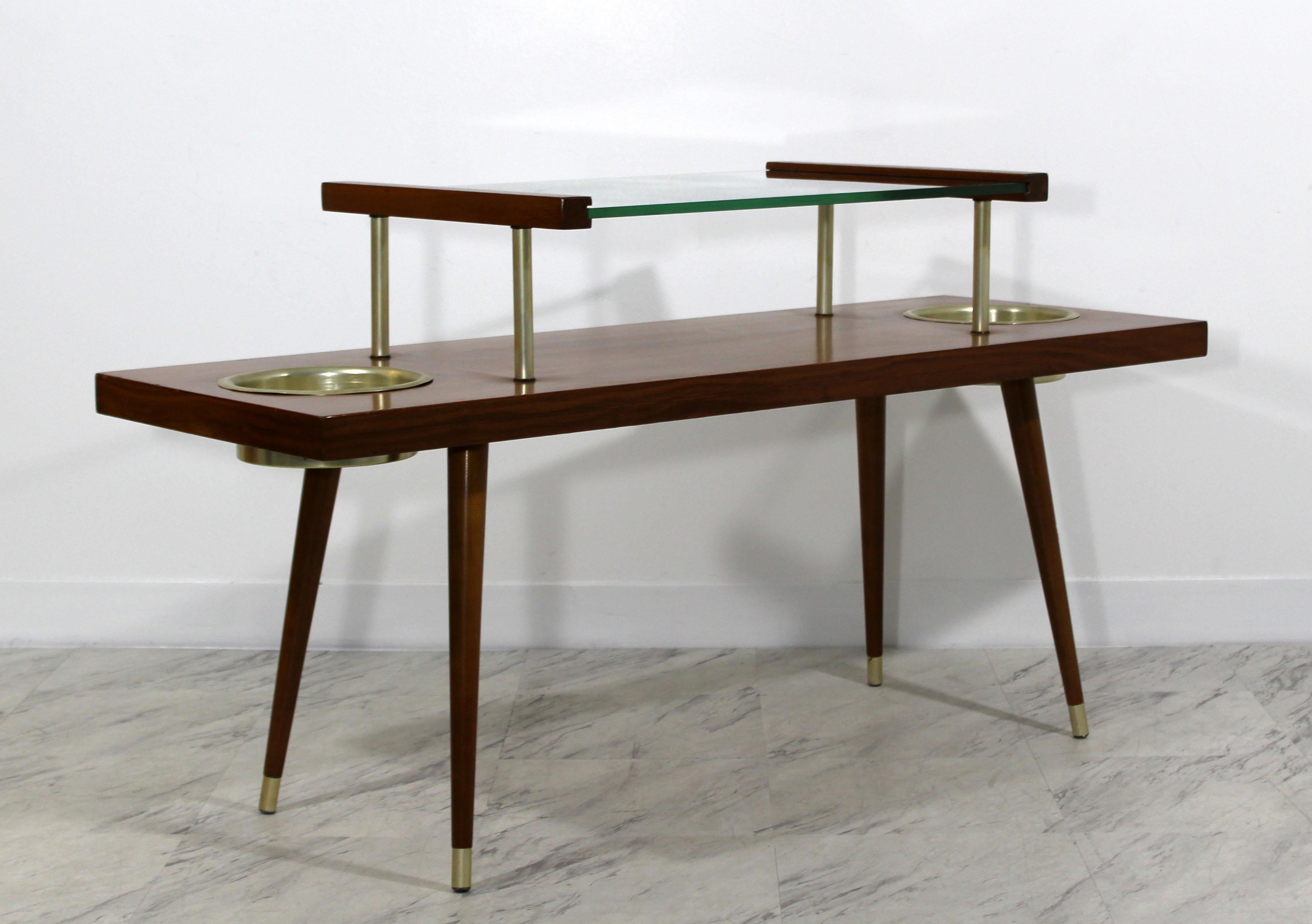For your consideration is an magnificent, walnut coffee table, made of walnut, with a tier glass top and two built-in brass planters, in the style of Paul McCobb, circa 1960s. In very good condition. The dimensions of the table are 48