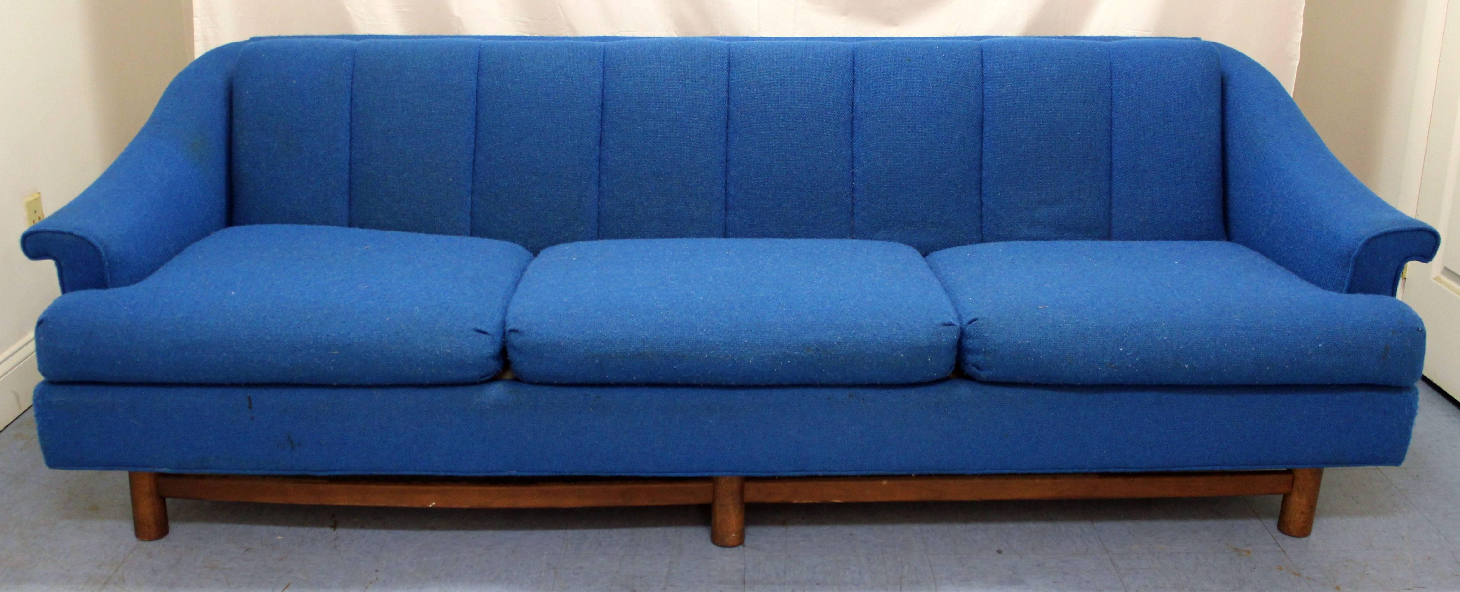 This is a midcentury sofa with blue upholster and wooden legs.