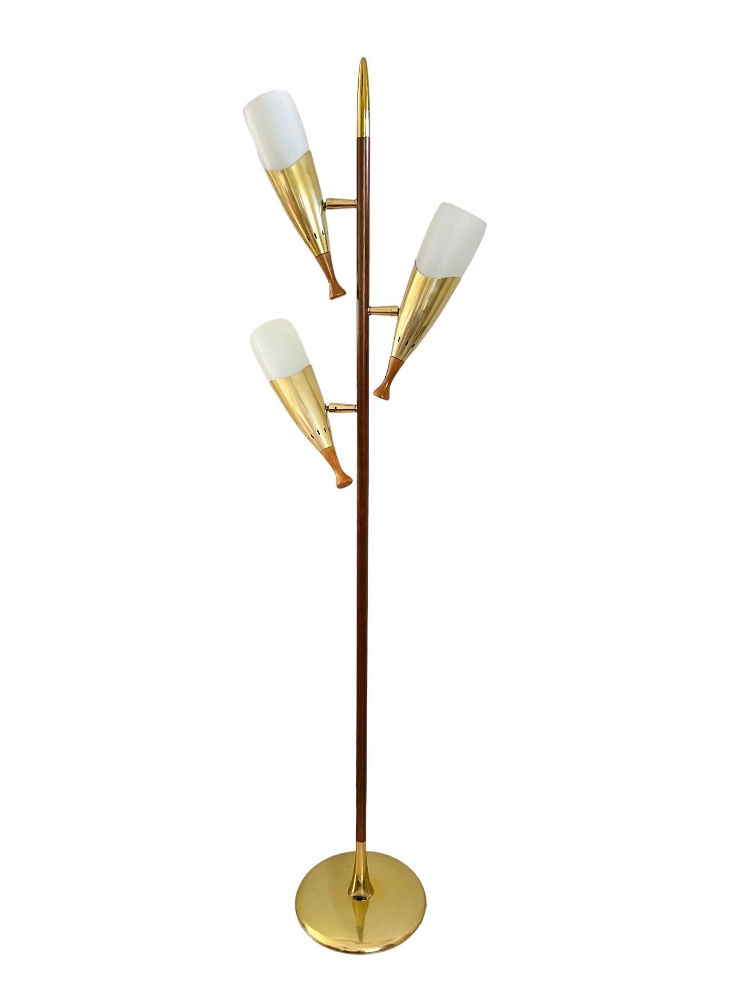 A vintage Mid-Century Modern flagpole floor lamp with three adjustable lights. Teak post with polished brass finial and base. Brass light fixtures and pivots with frosted glass shades and walnut rotary knobs. Includes 3 bulbs.

Dimensions: 18