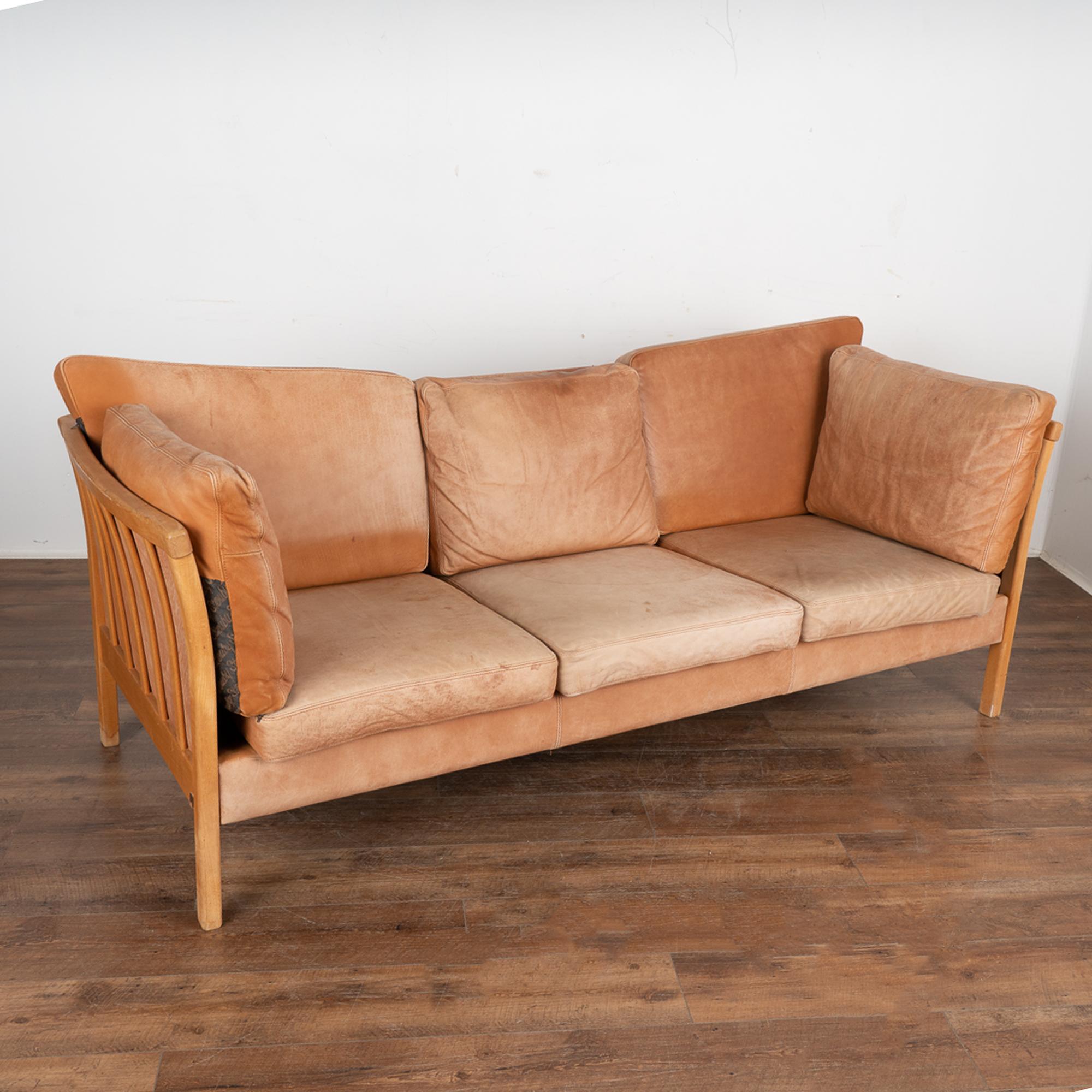 Mid-Century Modern Stouby three-seat sofa with removable cushions, frame in beech.
The years of use are revealed in the aged patina of the leather, including impressions, scuffs/scratches, stains, fading/discoloration throughout, etc. which all add