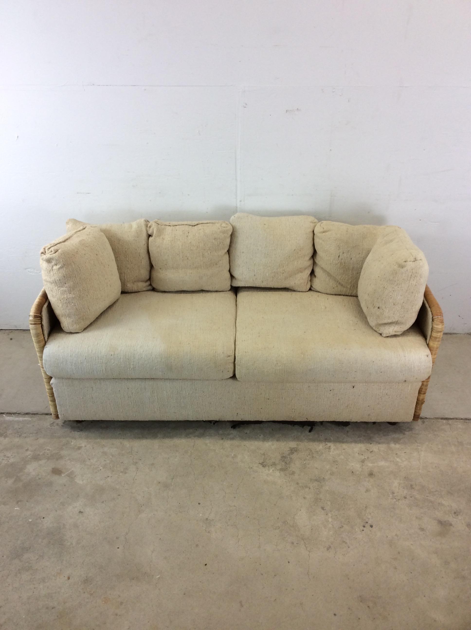 This mid century modern three seater sofa features wicker arms and sides with original finish and overstuffed removable cushions and backrest.

Dimensions: 60w 31d 28h 17sh 22ah 

Condition notes: Staining, fading and discoloration to the
