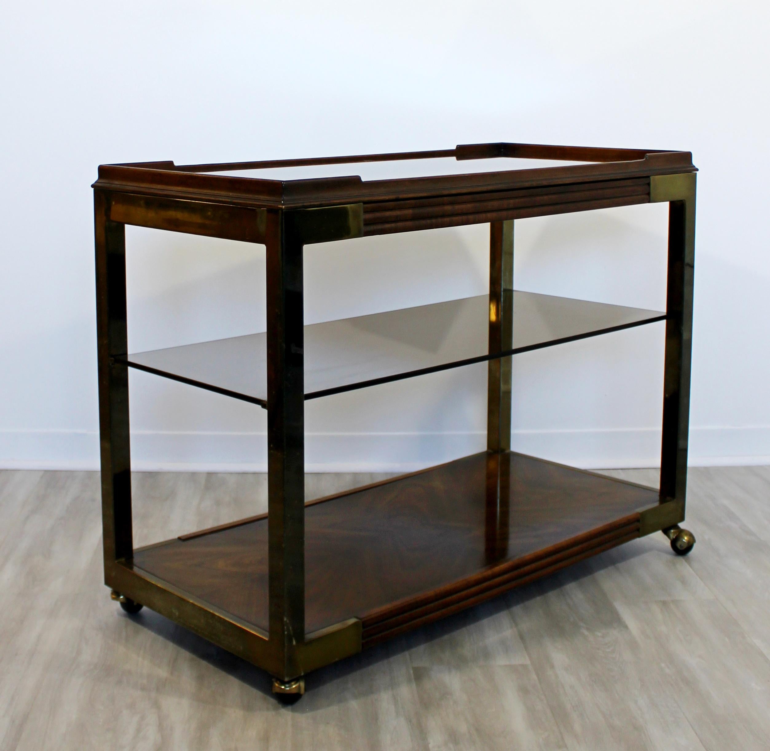 For your consideration is a fantastic, rolling bar or service cart, with three tiers; one wood, one glass and one mirrored, on a wood base, circa 1950s. In excellent vintage condition. The dimensions are 39.5