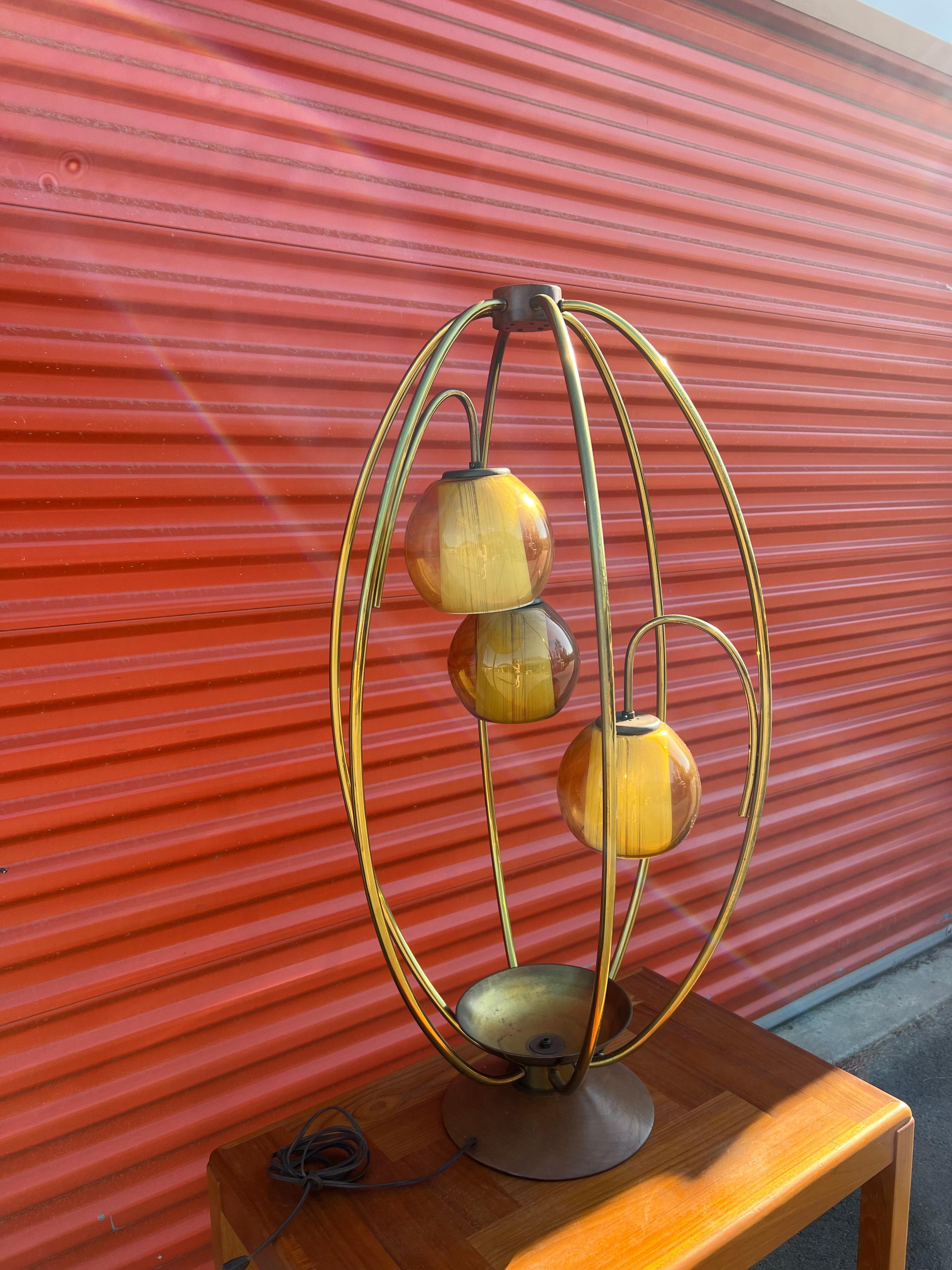 Unique Mid-Century Modern oval brass ‘bird cage’ table lamp with three glass globes. Some light wear and patina to the brass from age. Attributed to Modeline.