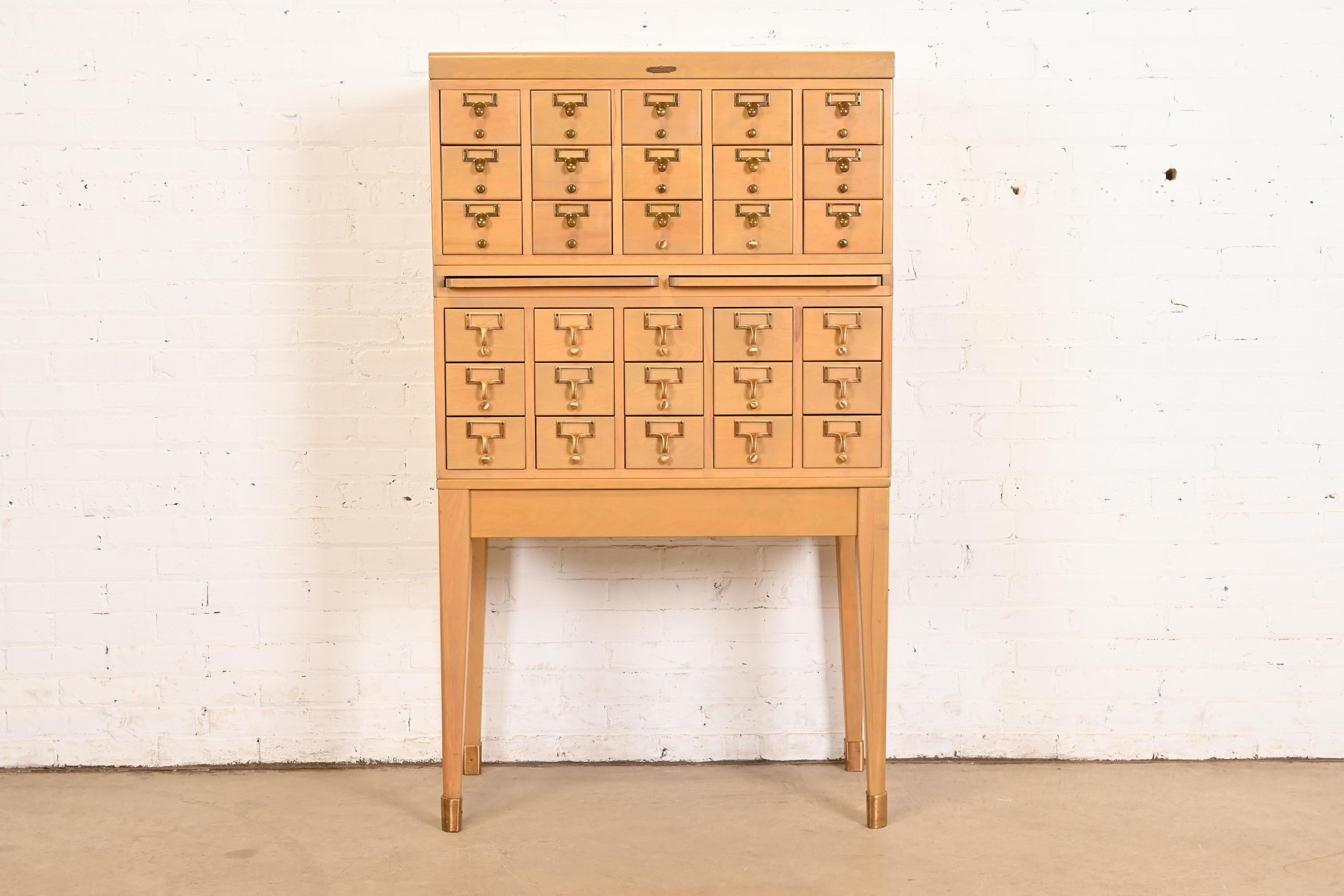 Un raro schedario o catalogo da biblioteca a 30 cassetti in stile Mid-Century Modern con due tavolette di scrittura estraibili

Da Remington Rand

USA, Circa anni '50

Acero, con ferramenta in ottone.

Misure: 33 