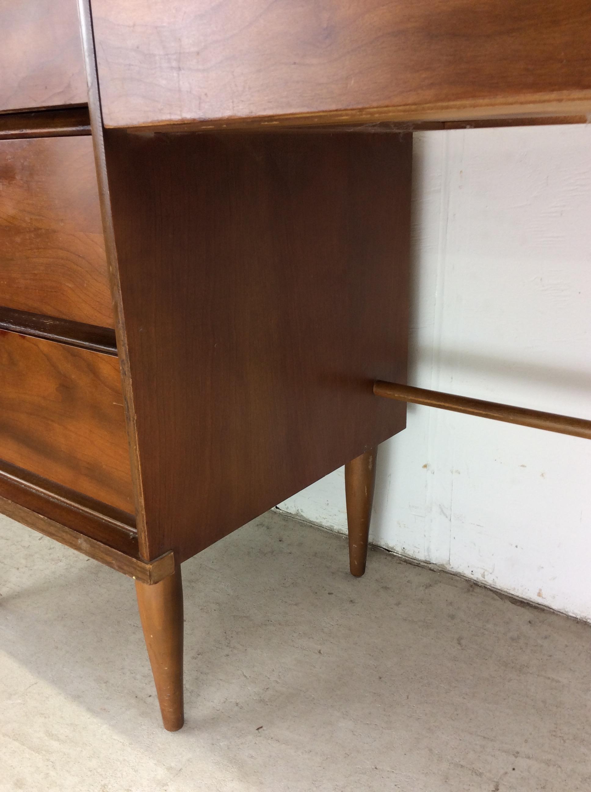 This mid century modern writing desk features hardwood construction, beautiful walnut veneer with original finish, four dovetailed drawers, wood top, and tall tapered legs.   Matching 6 drawer low dresser available separately. 

Dimensions: 44w 17d