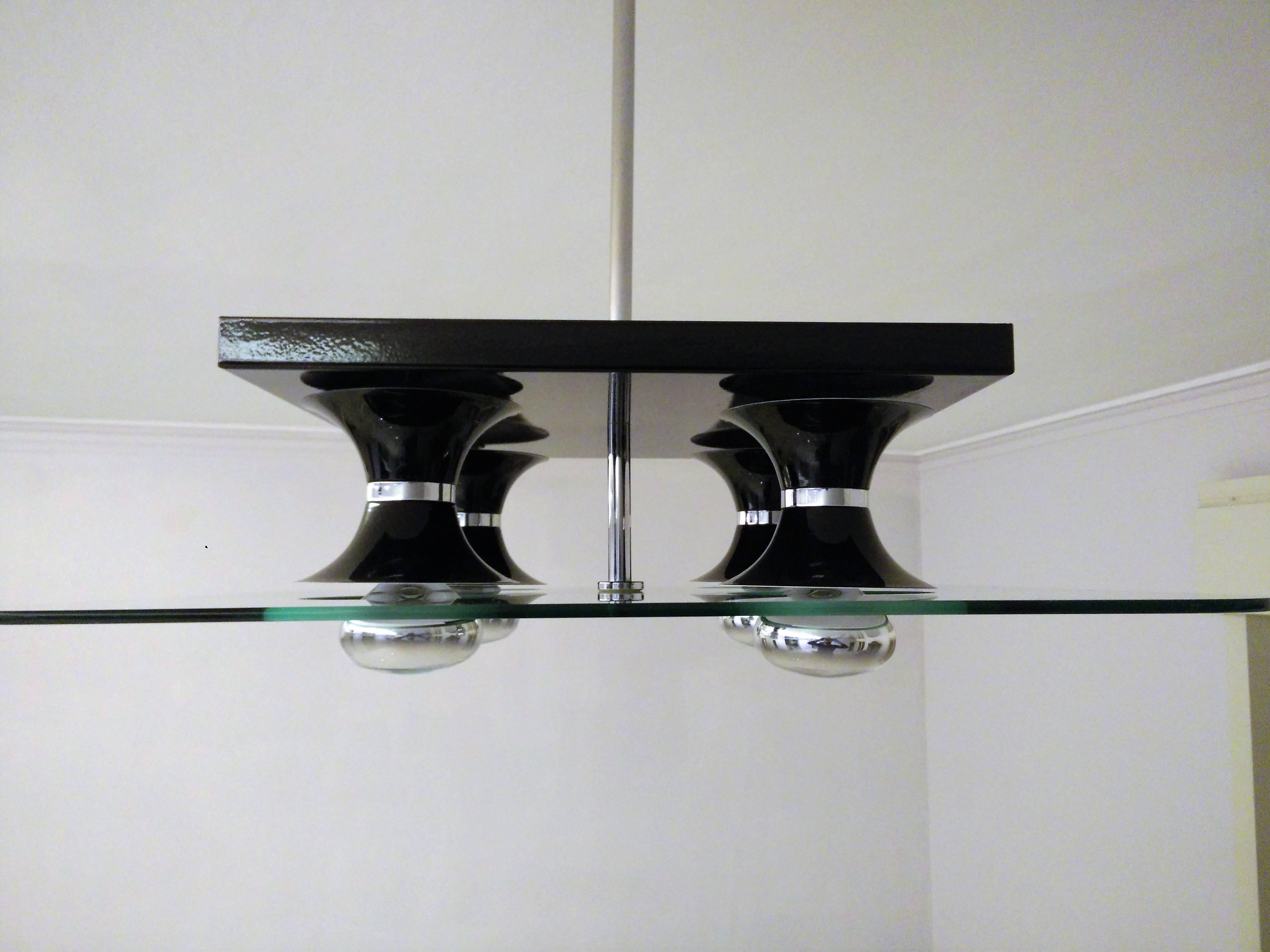 Mid-Century Modern Italian four-light chandelier, attributed to Stilnovo, in black lacquered metal and glass, circa 1970
Great condition throughout.
Measurements:
Glass 60 cm x 60 cm
Chandelier’s body, 40 cm long by 40 cm wide and 15 cm deep,
total