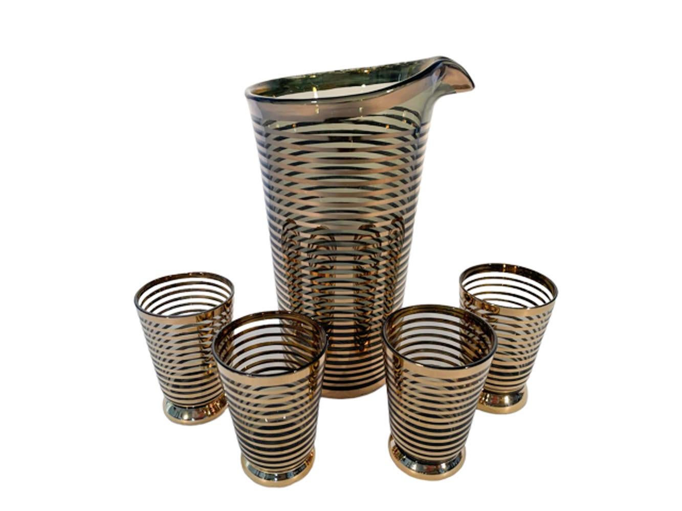 Five piece Mid-Century Modern cocktail set consisting of a handless cocktail pitcher with polished pontil and 4 footed cocktail glasses, in olive glass with 22k gold micro bands from bottom to top.