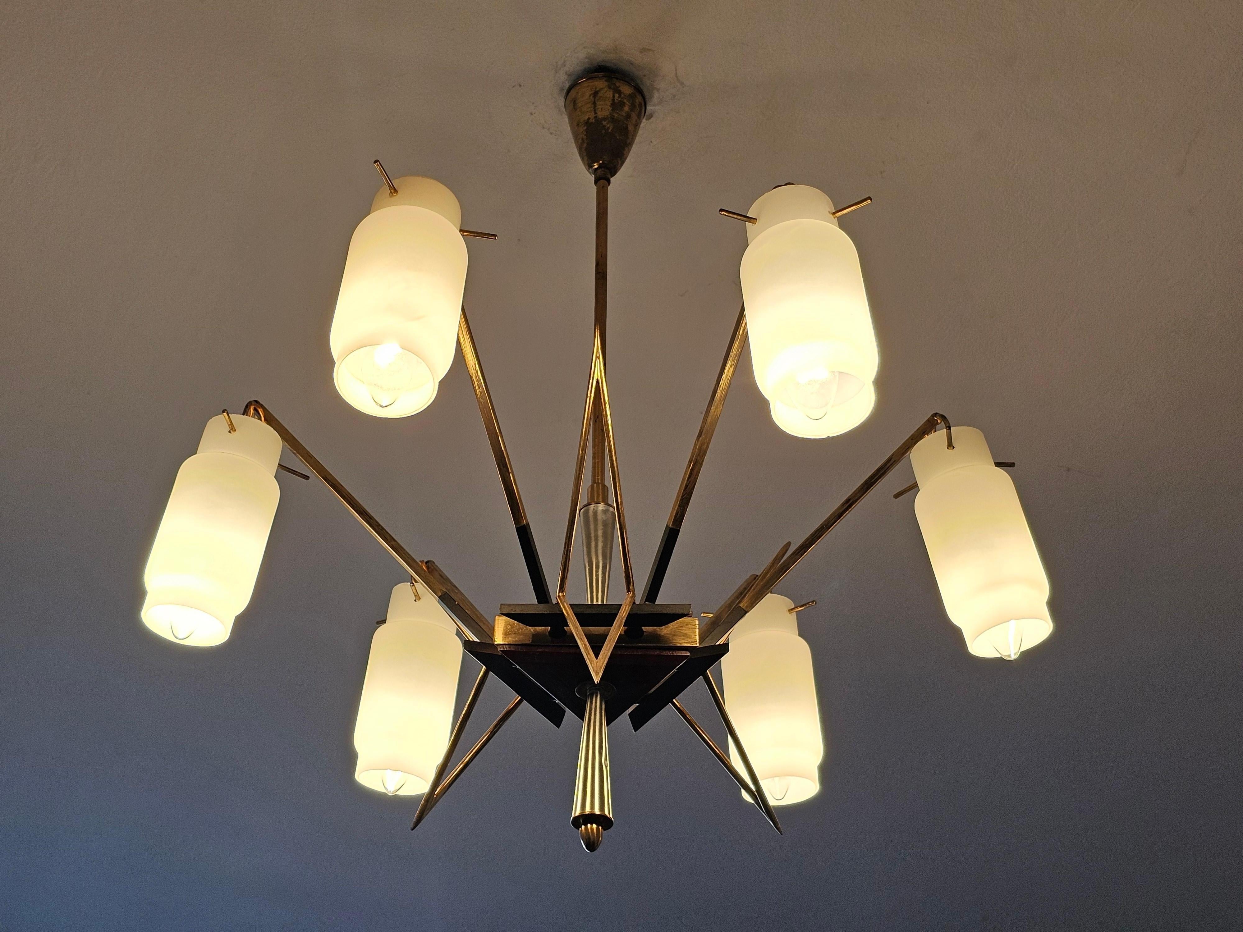 In this listing you will find a breathtaking Mid Century Modern 6-Arm chandelier by Stilnovo. It features geometric shaped fixture,, triangular and sharp, done in brass and teak, with beautiful opaline glass shades. Made in Italy in 1950s.

Very
