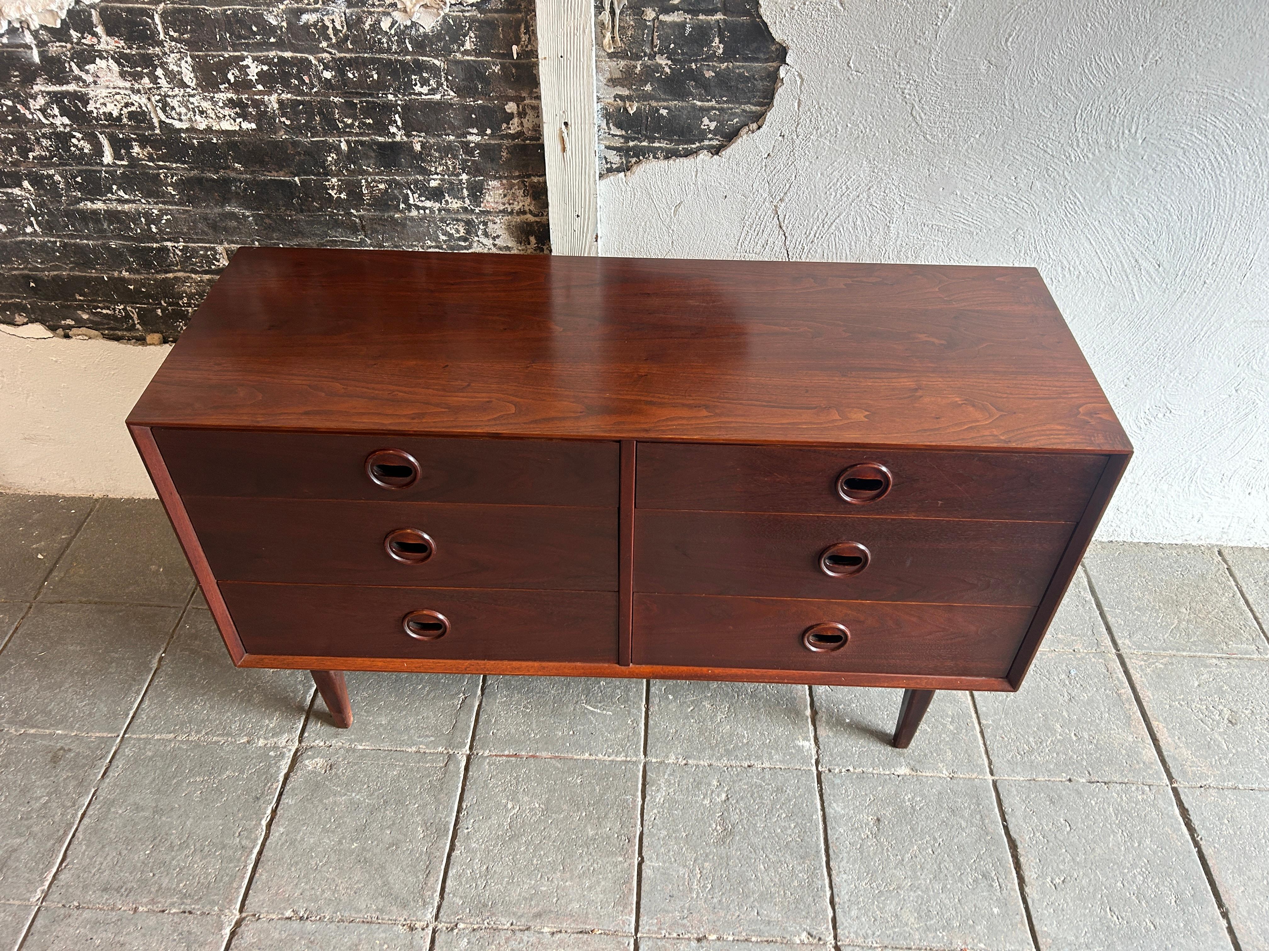 Unique mid century modern walnut 6 drawer dresser with carved handles. Dark reddish walnut wood Danish rosewood style with circular eye carved handle / Pulls. Dovetail solid oak drawer construction. Beautiful wood grain. Made in USA circa 1960.