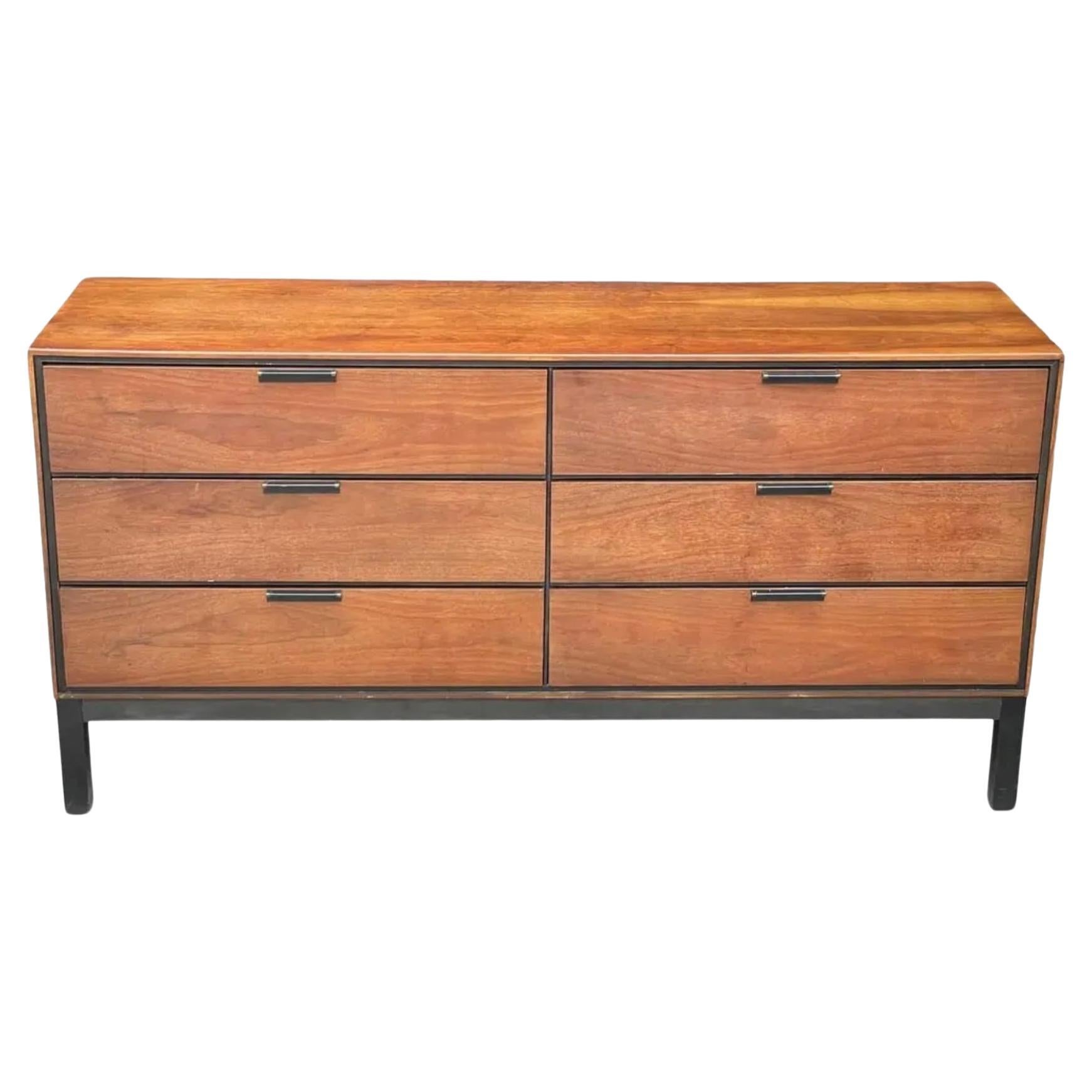 Preciosa cómoda baja de 6 cajones de madera de nogal moderna de mediados de siglo, con base de madera lacada en negro. Madera de nogal con detalles lacados en negro y su base tiene asas negras de perfil bajo Fabricado en EE.UU. Circa 1960. Situado