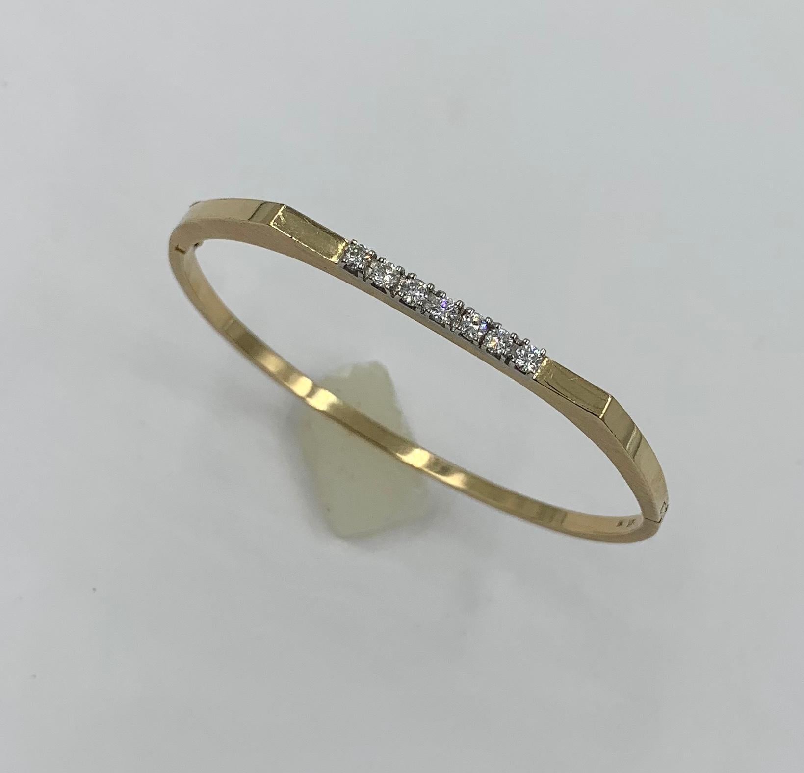 A wonderful and classic Mid-Century Modern Bangle Bracelet in 14 Karat Yellow Gold set with 7 sparkling white Diamonds.   The bracelet features 7 gorgeous white round brilliant cut diamonds which total approximately .56 Carats.  The diamonds are
