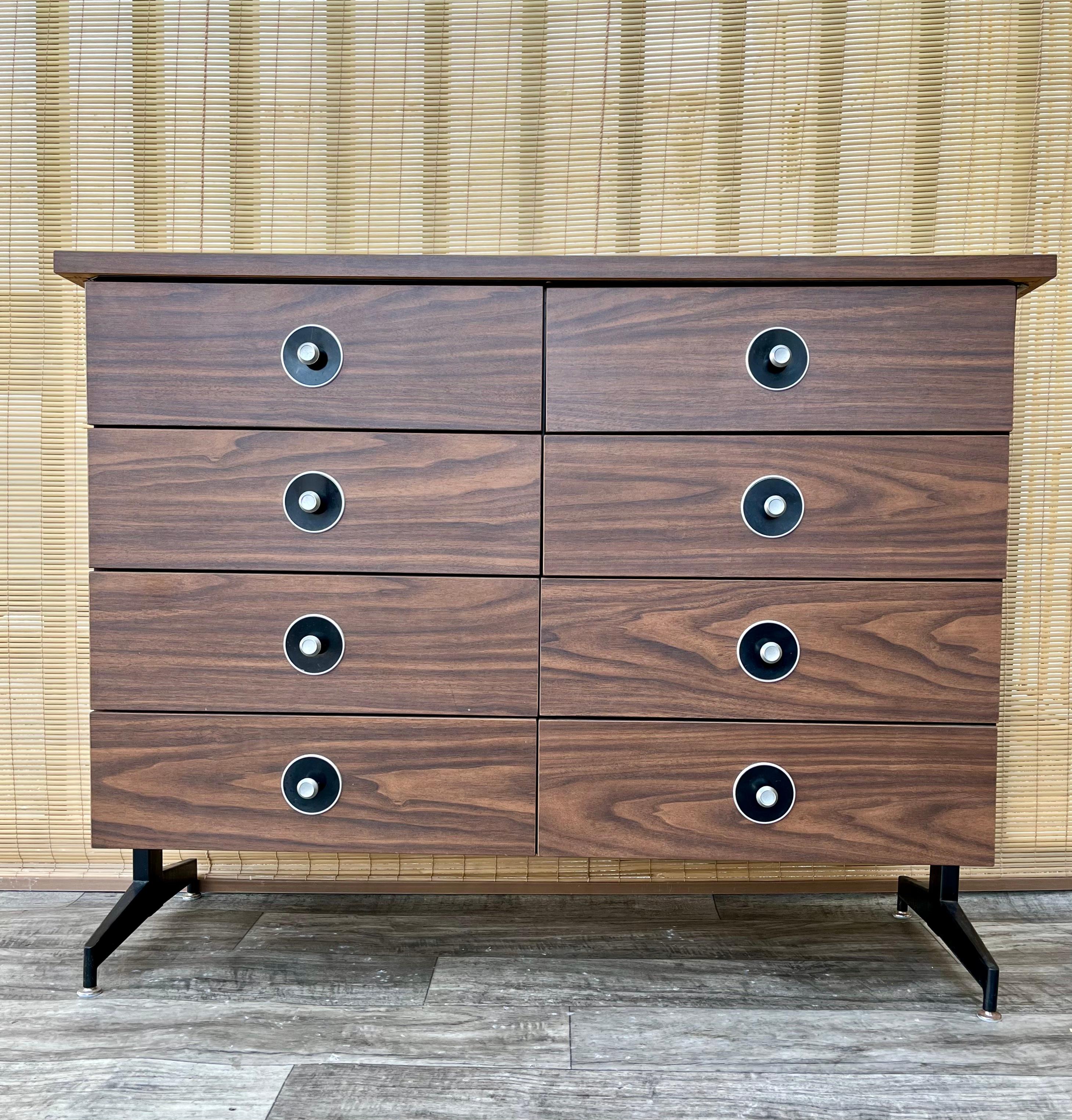 Comò galleggiante a 8 cassetti Vintage Mid-Century Modern. Circa anni '70.
Presenta una finitura in finto legno laminato, otto cassetti che offrono molto spazio per riporre oggetti extra, sostenuti da un piedistallo in metallo nero che conferisce
