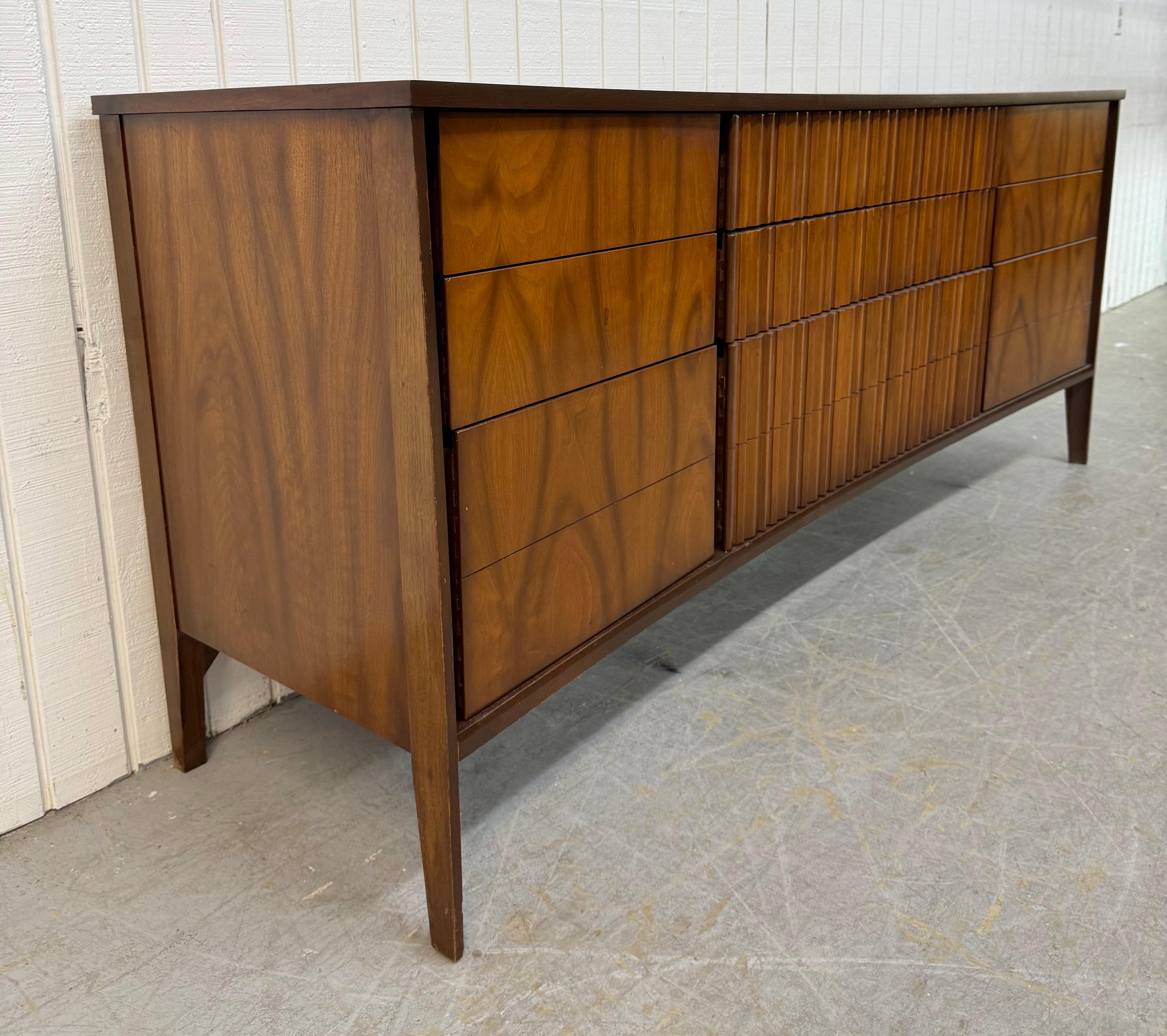Questo annuncio si riferisce a un comò in noce a 9 cassetti in stile Mid-Century Modern. Ha un design curvo, nove cassetti per riporre gli oggetti, gambe moderne e una splendida finitura in noce. Si tratta di un'eccezionale combinazione di qualità e