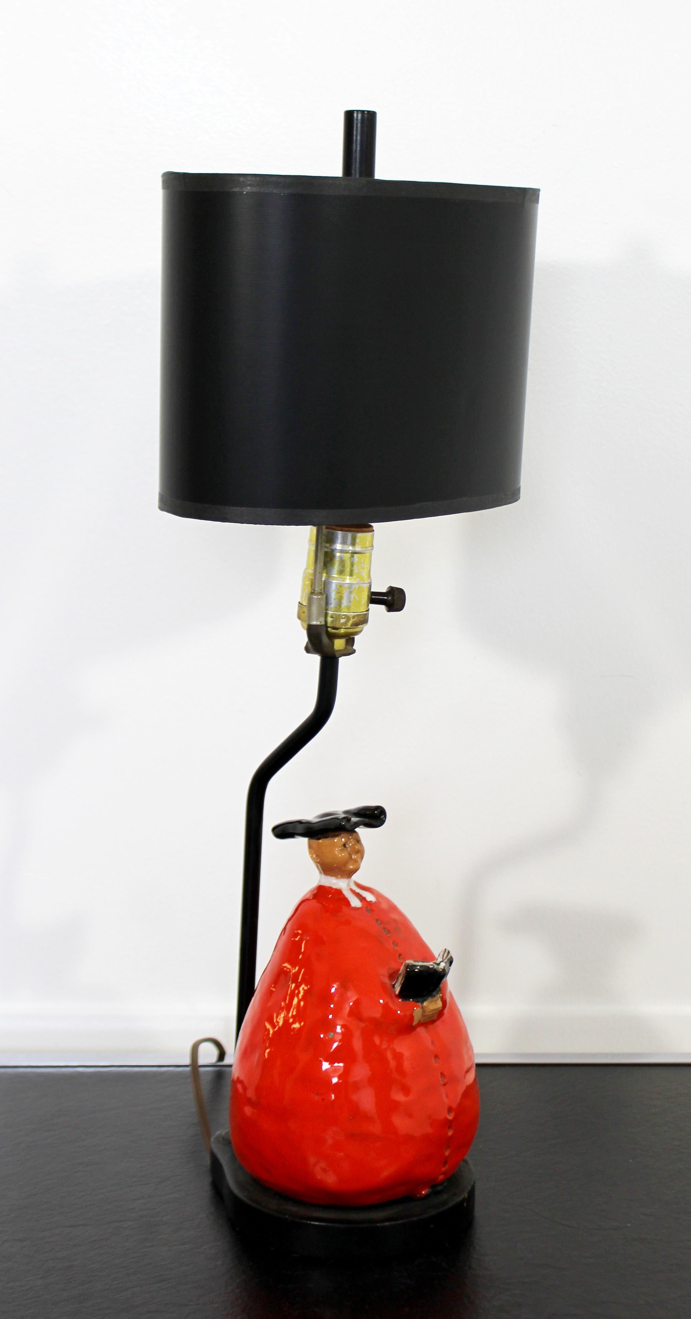 For your consideration is an amazing and rare, Italian ceramic table lamp, comprised of Abbot Monk Figurines in red, black and white glaze, circa 1950s. With wrought iron poles and wood bases. In good vintage condition. The dimensions are 8