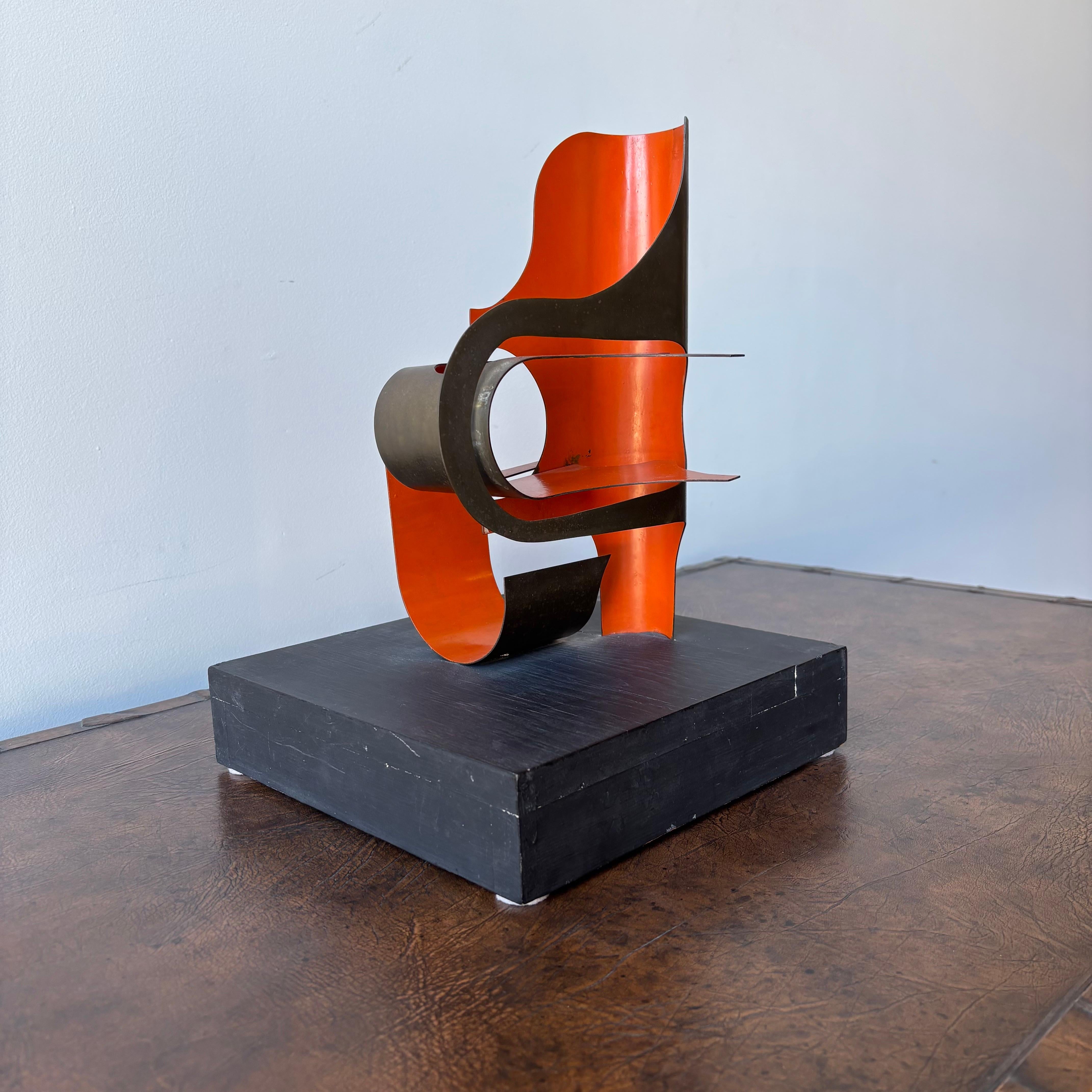 Un'impressionante scultura moderna vintage in ottone e smalto su una base di legno.  
Con le sue curve precise e gli elementi in ottone formati che si trafiggono l'un l'altro, questo pezzo ricorda le opere di Calder e Miro.   Una scultura da tavolo