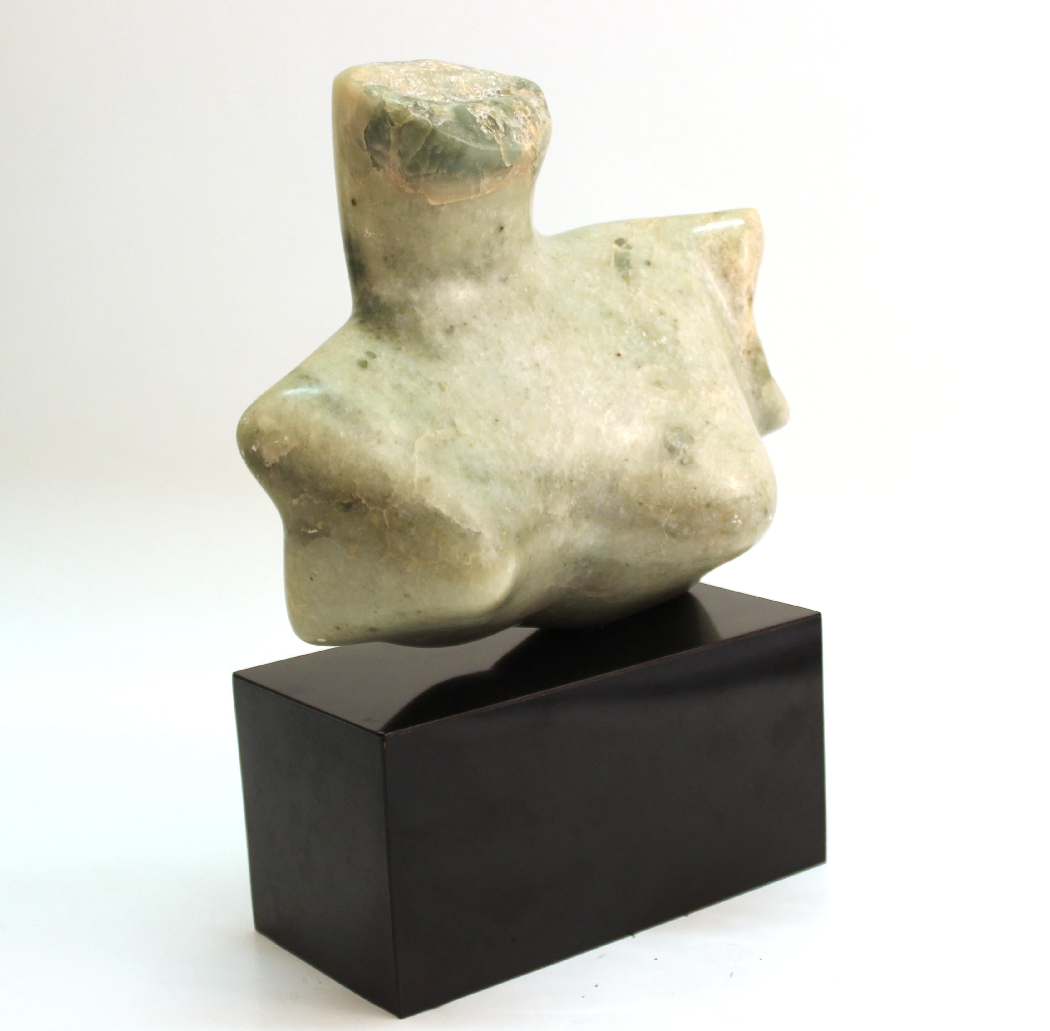 Mid-Century Modern abstract sculpture depicting a female chest or bust, carved in stone. The piece sits atop a black base and is unsigned. In great vintage condition with age-appropriate wear and use.