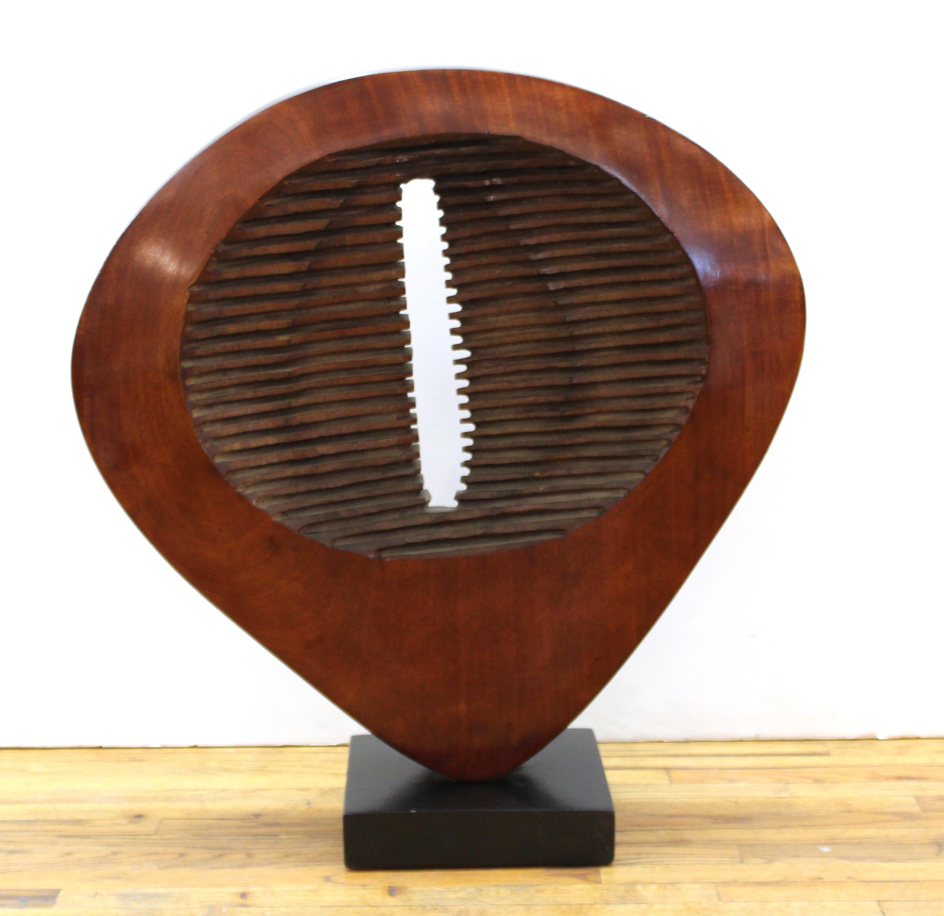 Mid-Century Modern abstract carved wood disc sculpture mounted on a square ebonized wood base.
