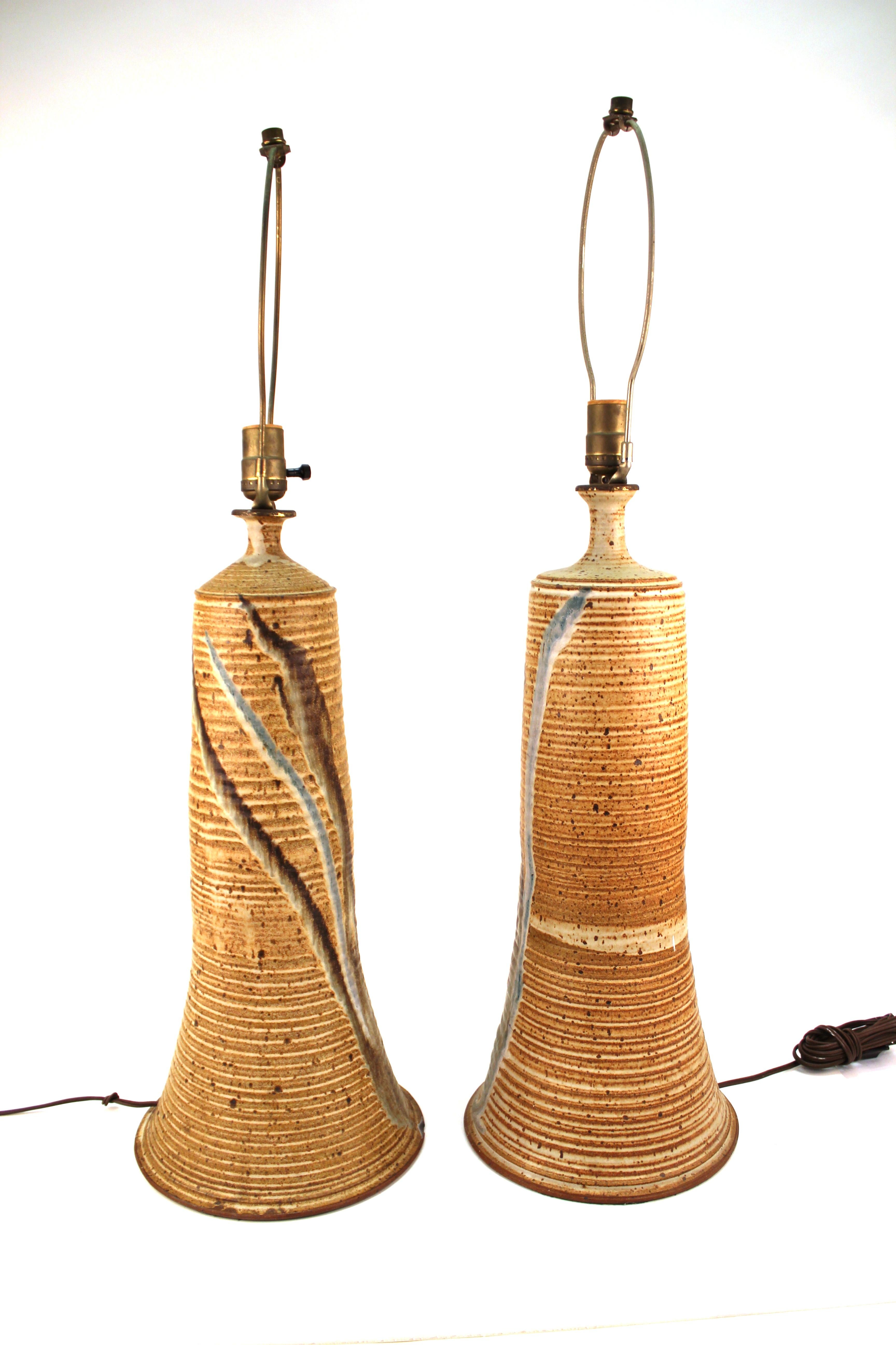 Mid-Century Modern pair of art ceramic table lamps with abstract painted lines on the front. The pair is in great vintage condition with some age-appropriate wear to the bases.
