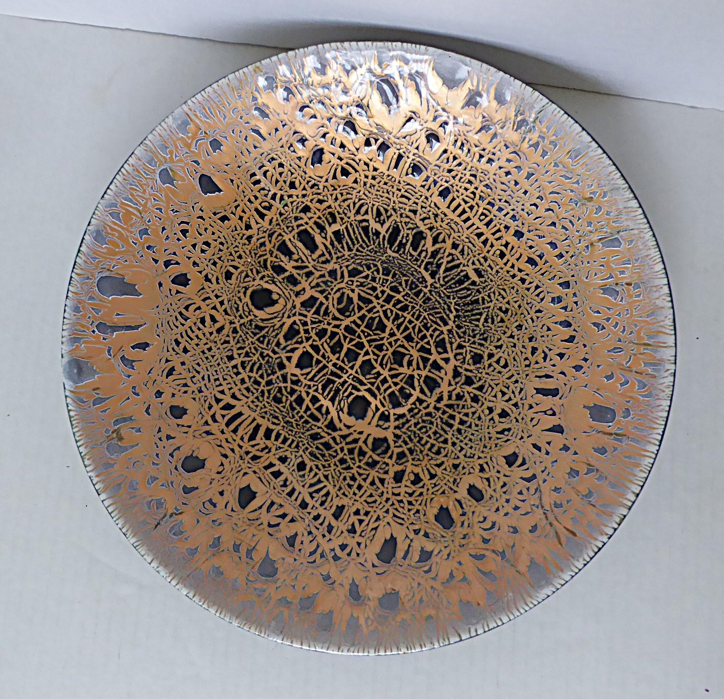 Elegant et riche plat en cuivre émaillé de Harold Tishler datant des années 1950. Le fond cuivré vif brille à travers l'émail gris très foncé qui s'estompe pour laisser place à un bord extérieur gris très clair. Les bords sont repliés pour créer une