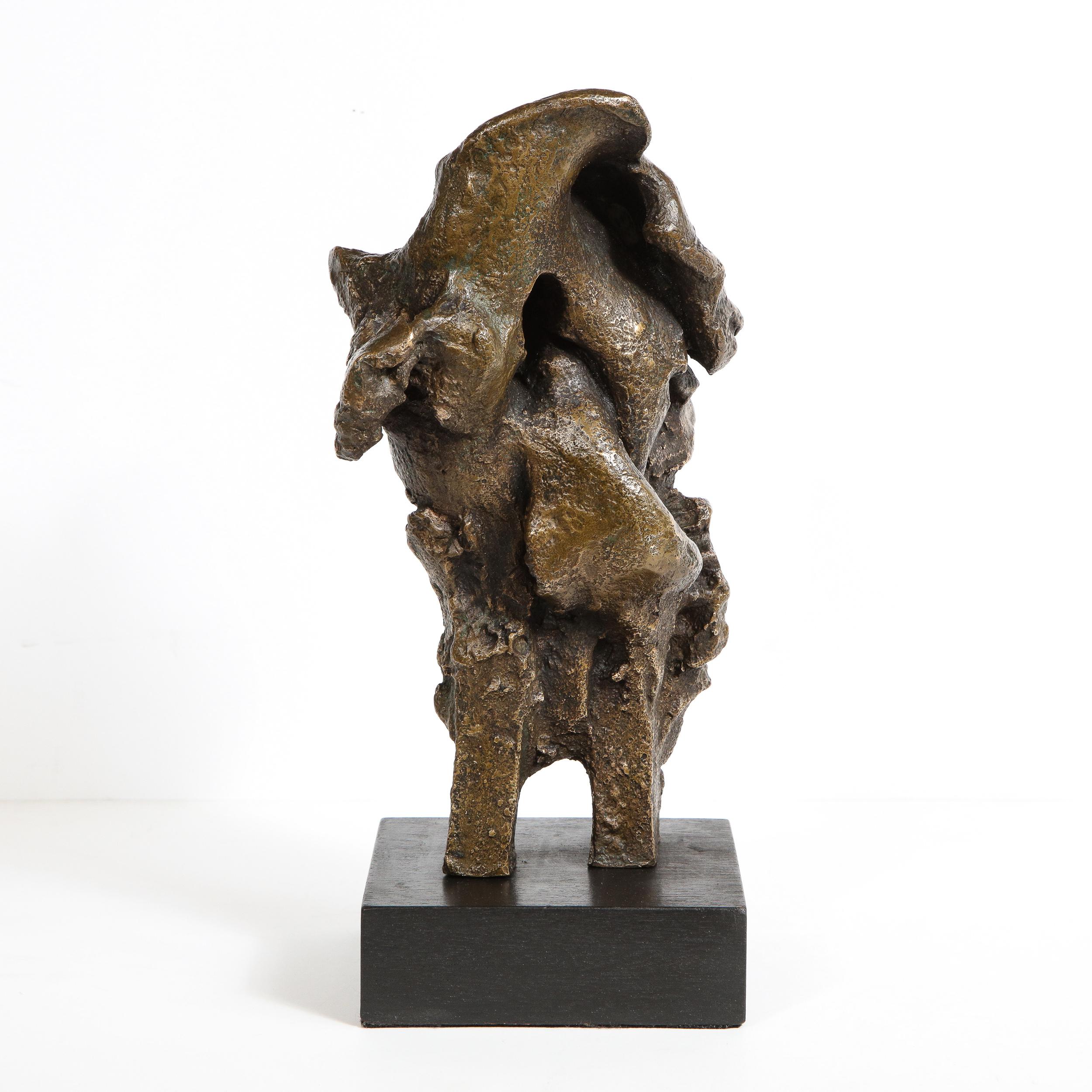 This refined Mid-Century Modern sculpture was realized in 1960. Presented on a volumetric rectangular ebonized wood base, the piece features an abundance of intermingling organic forms- full of verve and dynamism- with a richly textural surface.