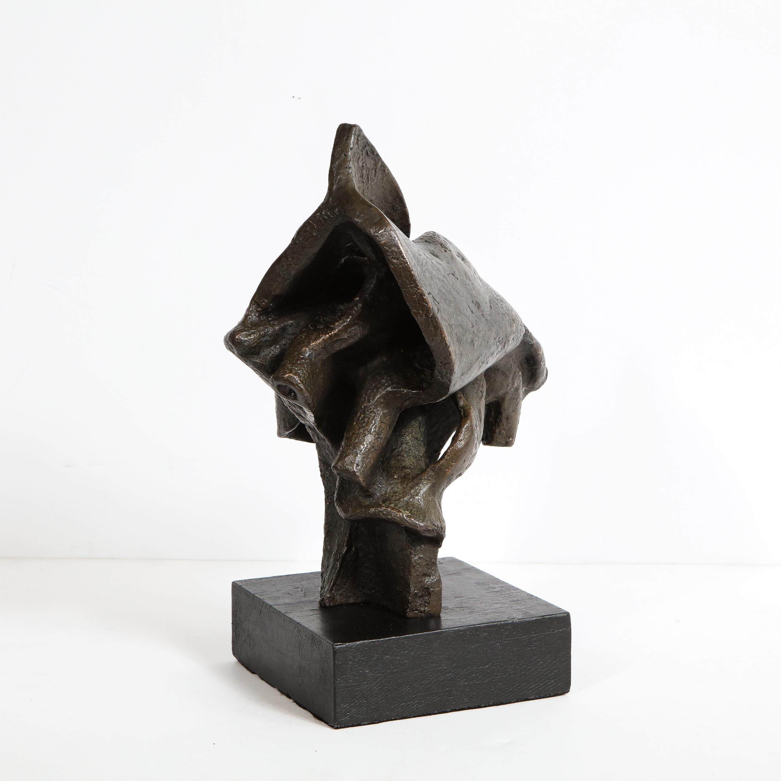 This sophisticated Mid-Century Modern sculpture was realized in 1960. Presented on a volumetric rectangular ebonized wood base, the piece features an abundance of intermingling organic curvilinear forms, full of verve and dynamism. While the piece