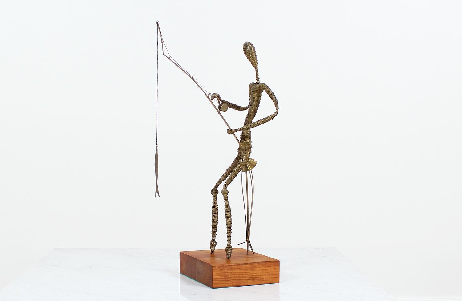Mid-Century abstract sculpture made in the United States circa 1960’s. This metal fisherman sculpture is mounted on a squared teak wood base and shows a beautiful patina on the metal from age. Brass wires are bound together to create an abstract