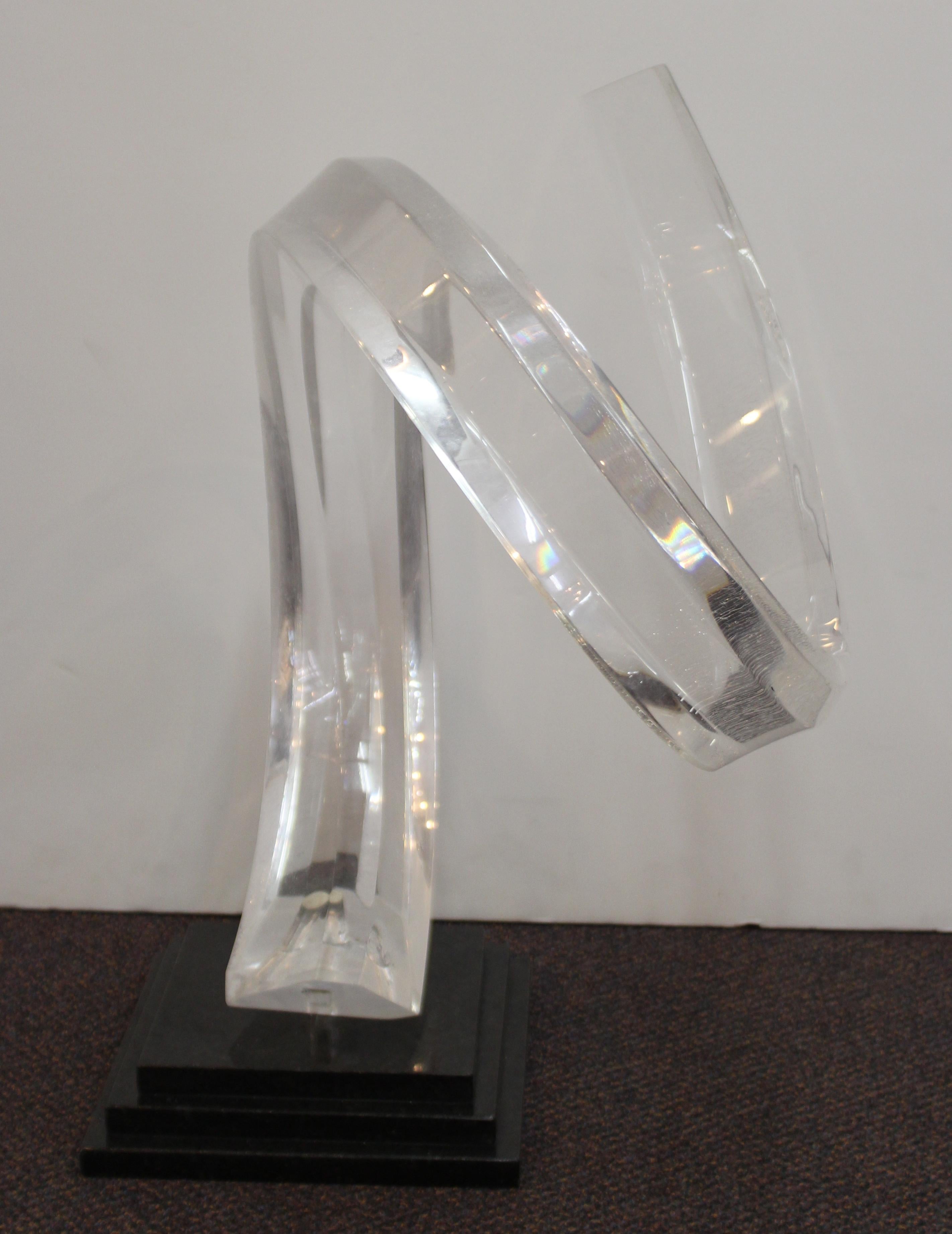 Mid-Century Modern abstract clear Lucite sculpture of a swirl, mounted atop a stepped black stone base. The piece is signed 'Seewack' on the base of the Lucite. In good vintage condition with age-related cracking across the Lucite and some