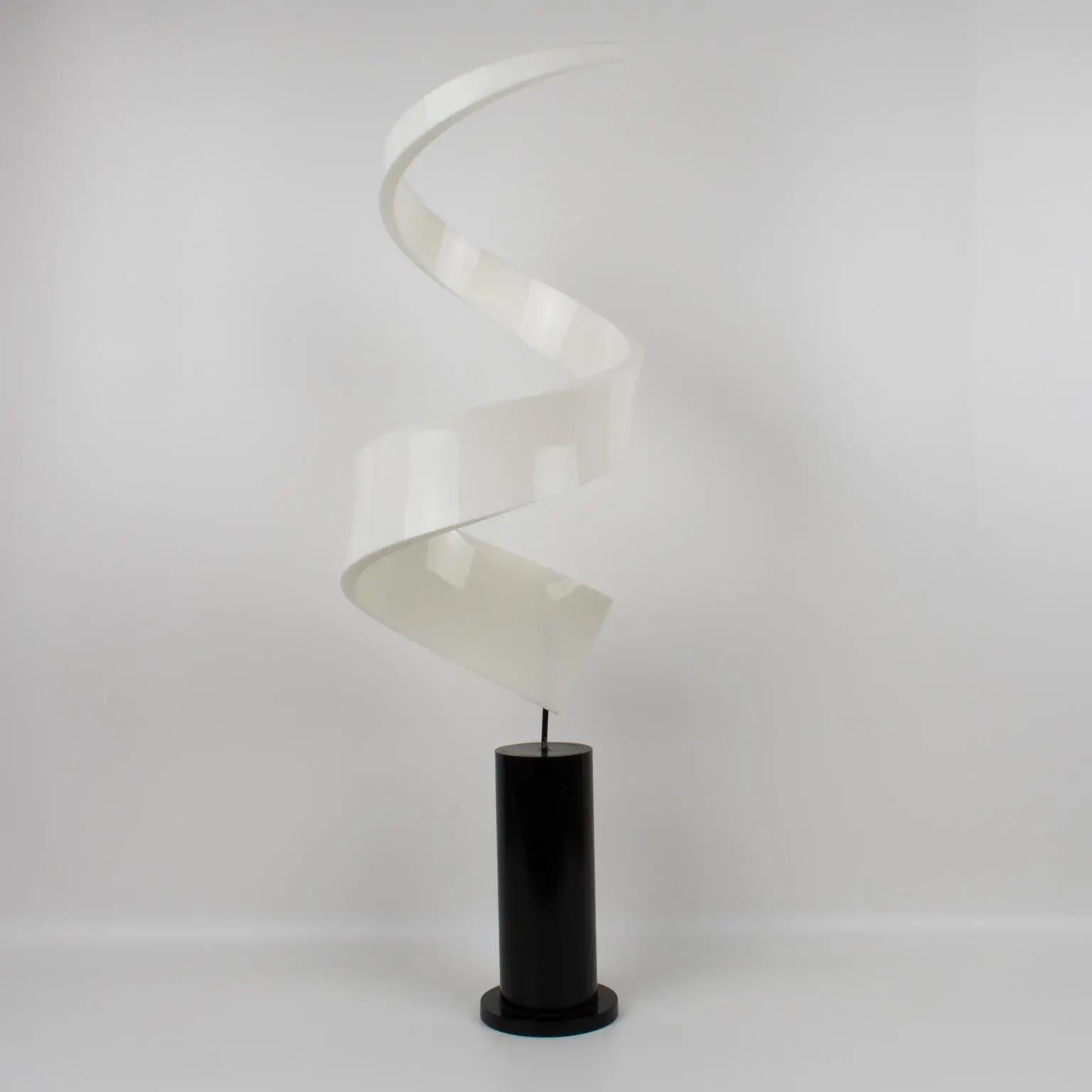 Stunning 1970s Lucite or Plexiglass sculpture. Abstract geometrical swirl shape, with milky white color mounted on a tall, stepped black Lucite or acrylic base. The piece boasts different visual effects from each side. There is no visible maker's
