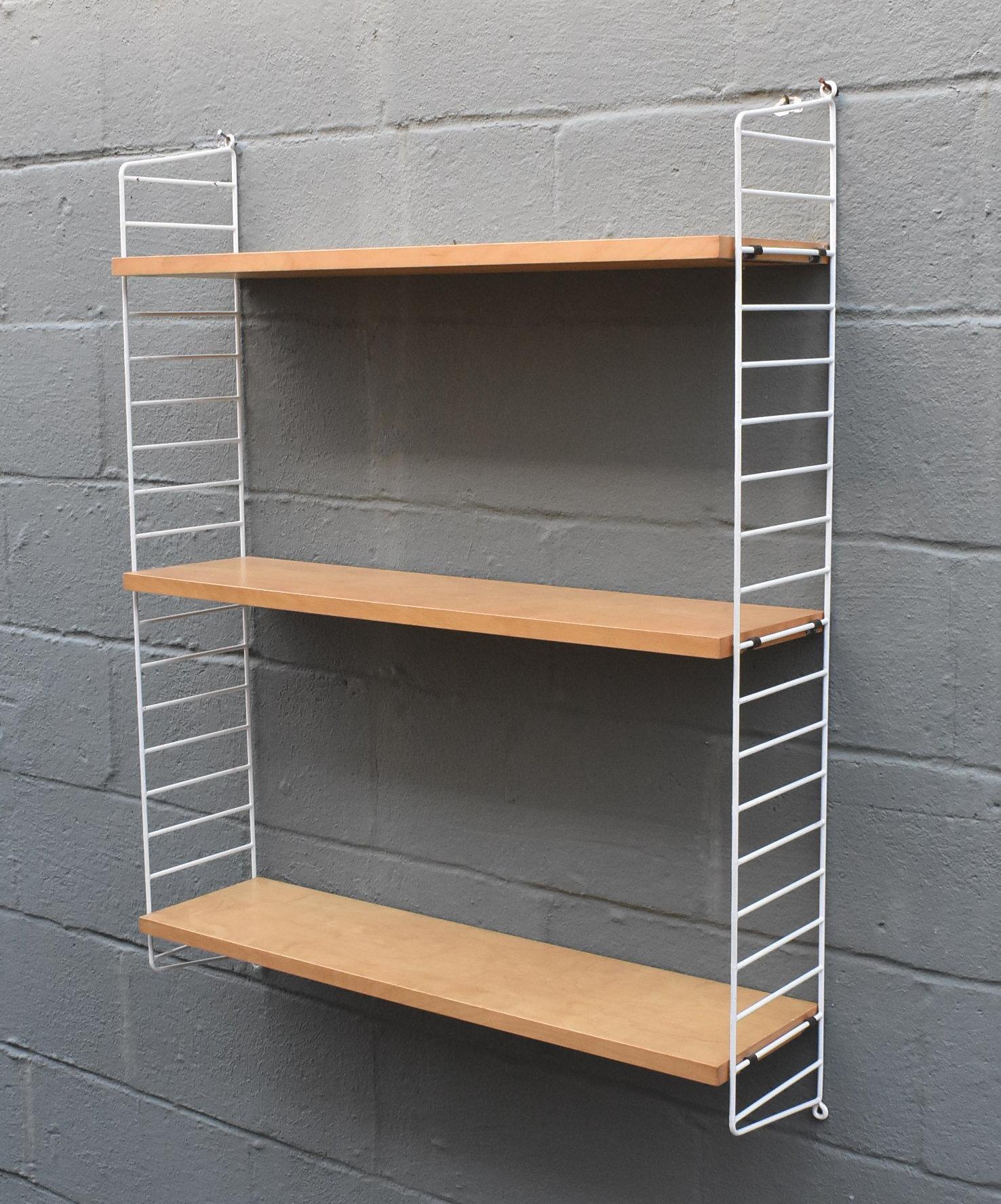 Mid-Century Modern adjustable wall shelves. Constructed of birch and coated wire. Made by String in Sweden. Measures: 39