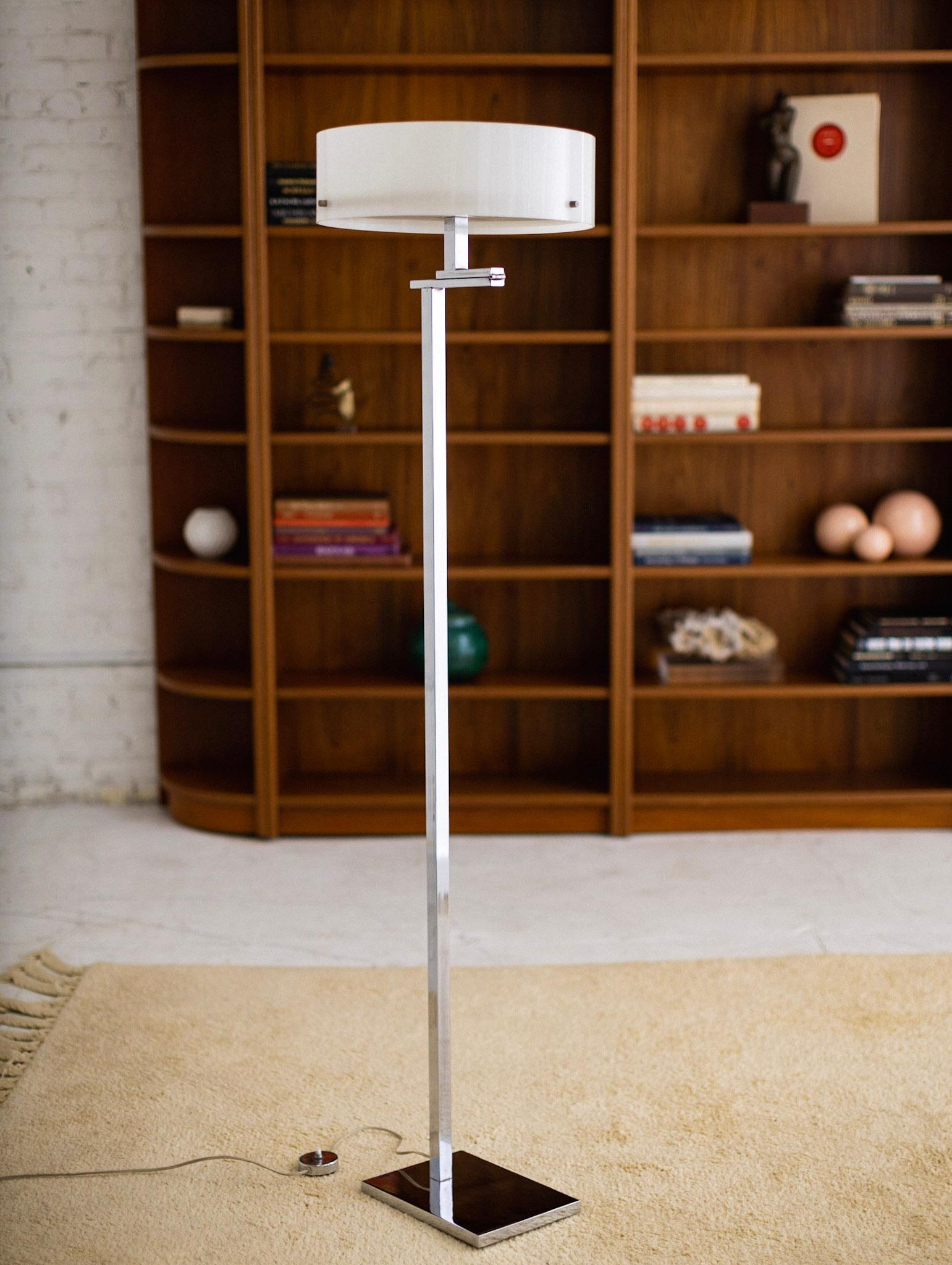 Chrome floor lamp with acrylic shade, which can be adjusted into two positions. Fashioned with a chrome on/off switch. Takes three lightbulbs.

Additional measurements: 
With shade down: 16” W x 19” D x 55.5” H
With shade up: 16” W x 16” D x