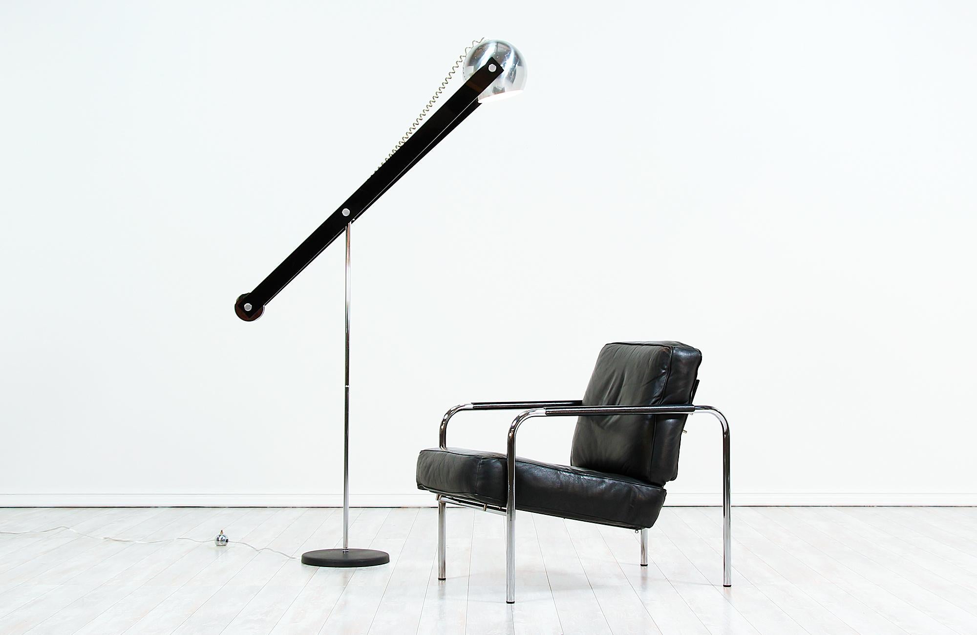 Adjustable chrome orb floor lamp designed and manufactured in the United States, circa 1970s. This retro modernist lamp features a polished chrome metal body and hardware that is perfectly complemented by the black Lucite arm and black metal base.