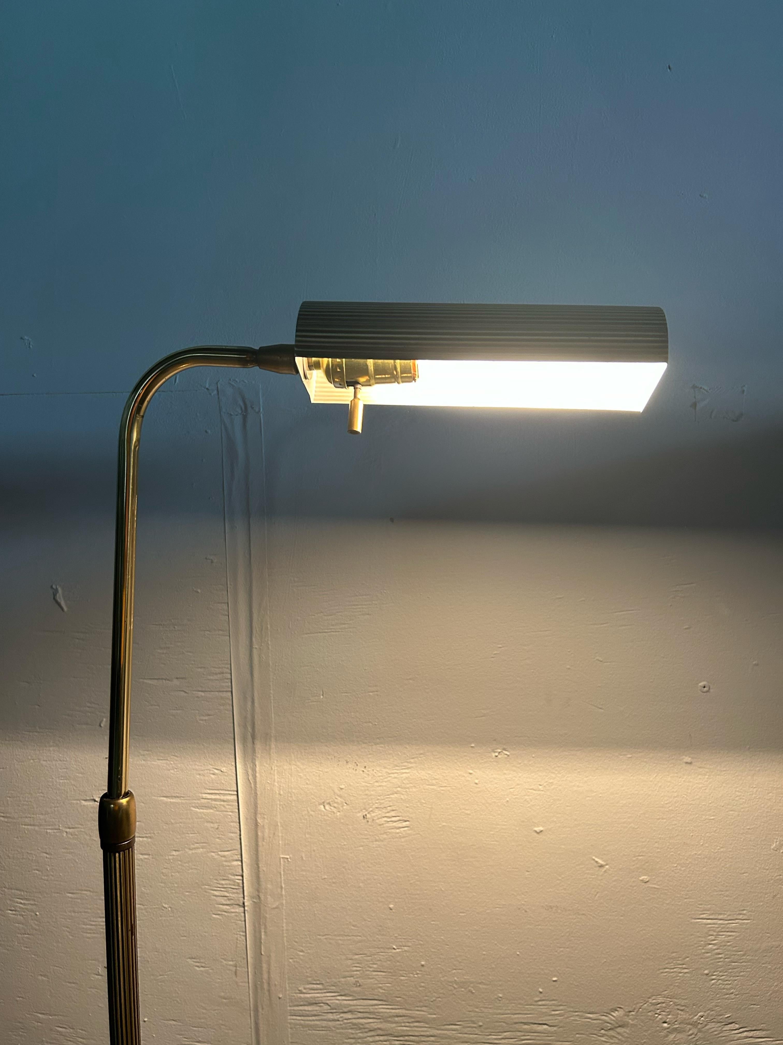 Ce lampadaire moderne du milieu du siècle présente une belle finition en laiton, un abat-jour multidirectionnel en laiton plissé, un col réglable en hauteur et une base biseautée unique.
u2028Dimensions : 18w 9d 48.5h 

Condit : Légère oxydation sur
