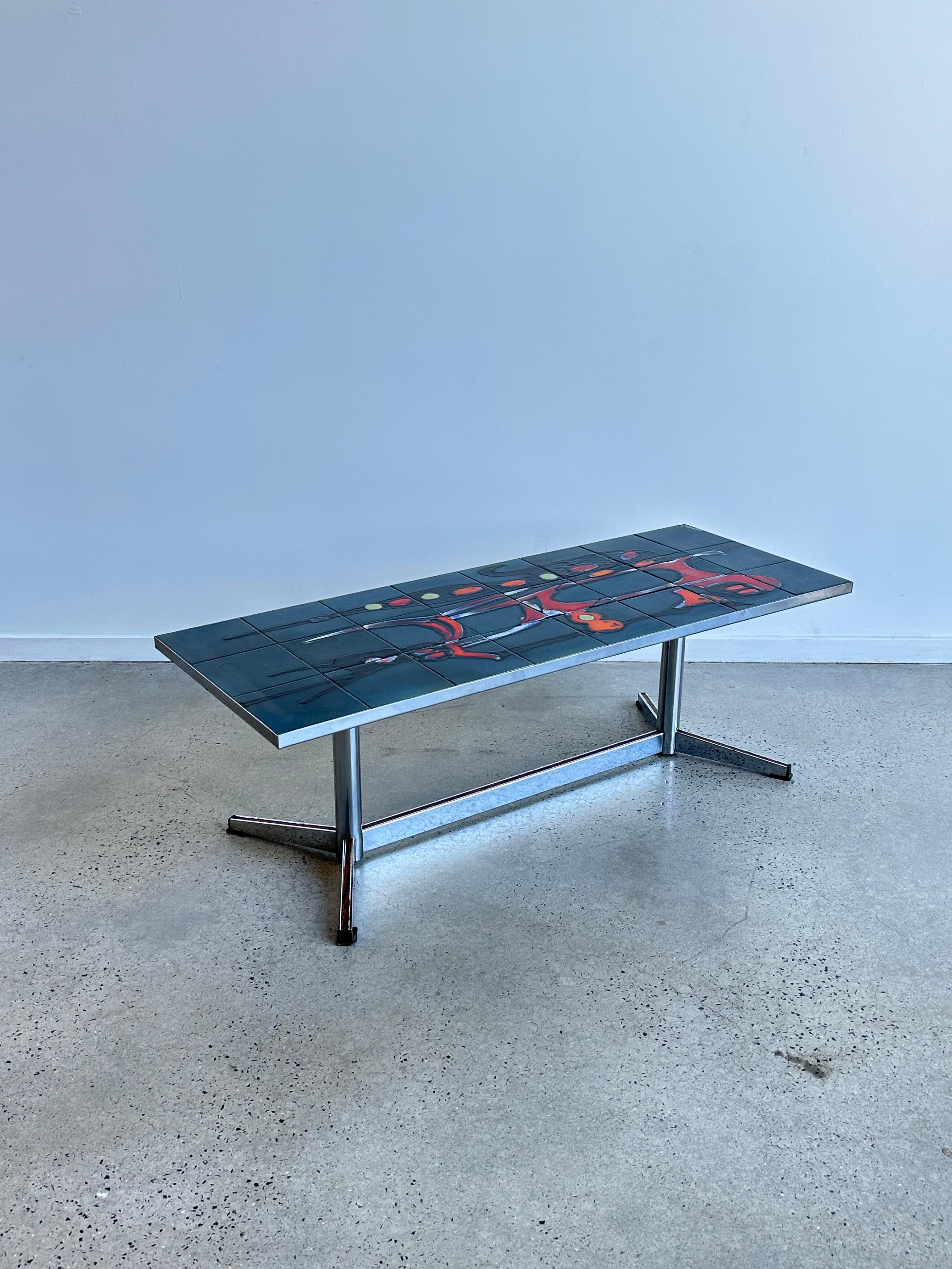 Es una mesa de centro única y llamativa que presenta un tablero de cerámica en una combinación de colores verde, rojo y naranja.

La base de la mesa suele ser de madera, y puede tener un diseño sencillo y aerodinámico que complemente el tablero