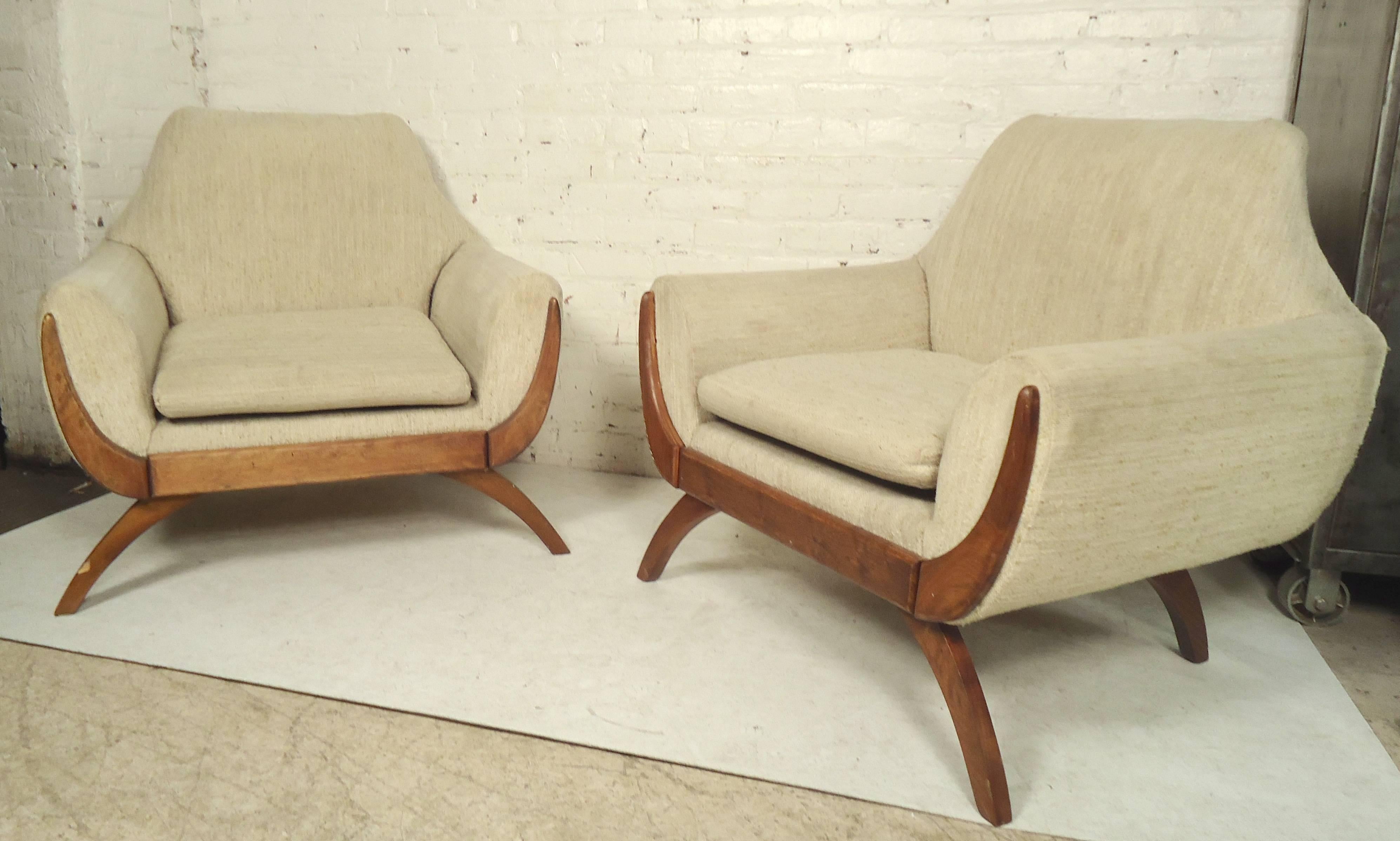 Pair of wide lounge chairs with unique wood trim and sculpted legs.

(Please confirm item location - NY or NJ - with dealer).
 