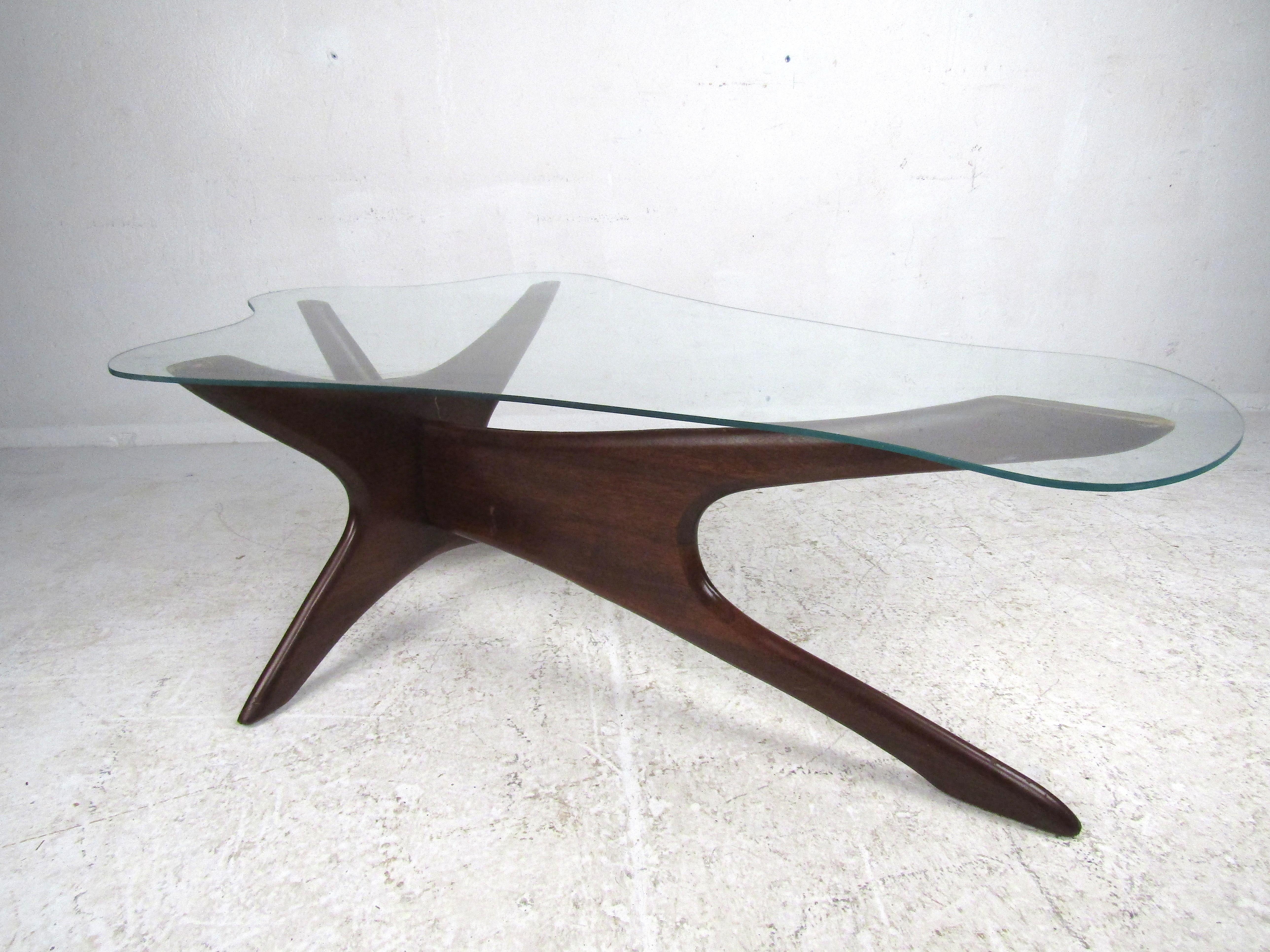 Unique Mid-Century Modern coffee table designed by Adrian Pearsall with an unusually shaped glass-top. Sturdy construction with a sculptural Jax style wooden base with a dark finish applied. Eye-catching table that is sure to be a great addition to