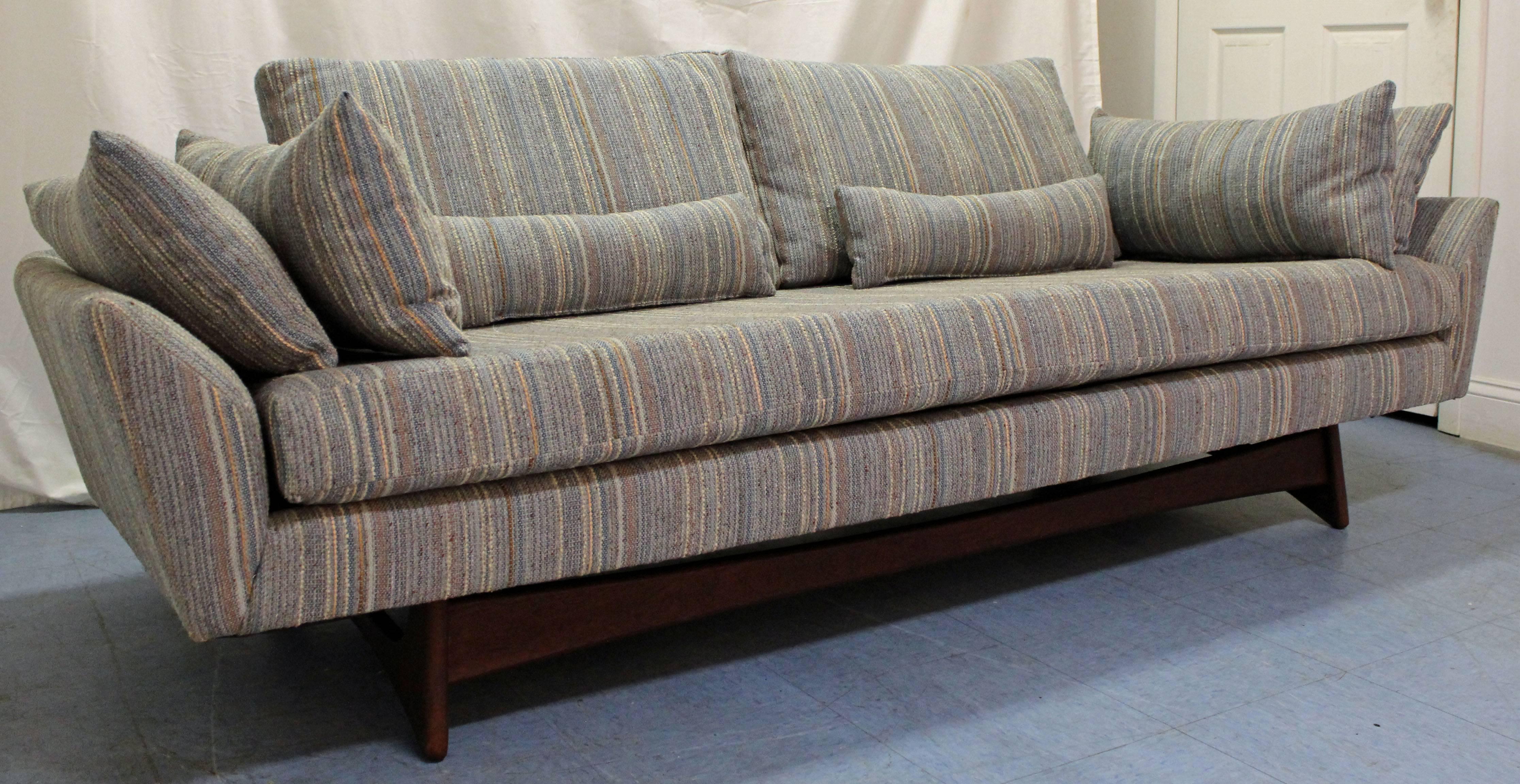 This sofa was designed by Adrian Pearsall for Craft Associates. Features sculpted walnut legs and has been reupholstered by the previous owner, who added extra throw pillows as well.

Dimensions:
86