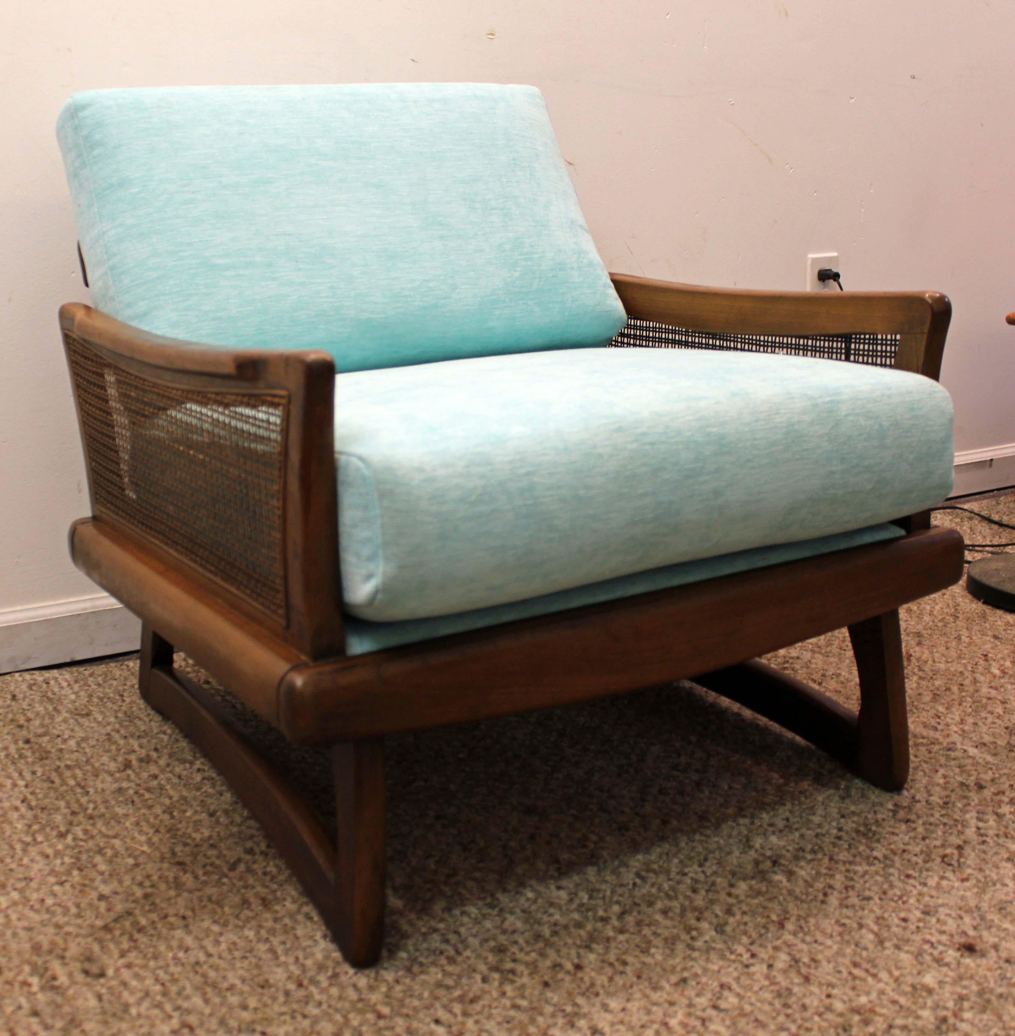 Offered is a beautifully reupholstered lounge chair. It is made of walnut with caned sides and boomerang legs. The chair is in excellent condition, showing minor wear (newly reupholstered, new cushions, small marks/scratches on wood, wear on cane