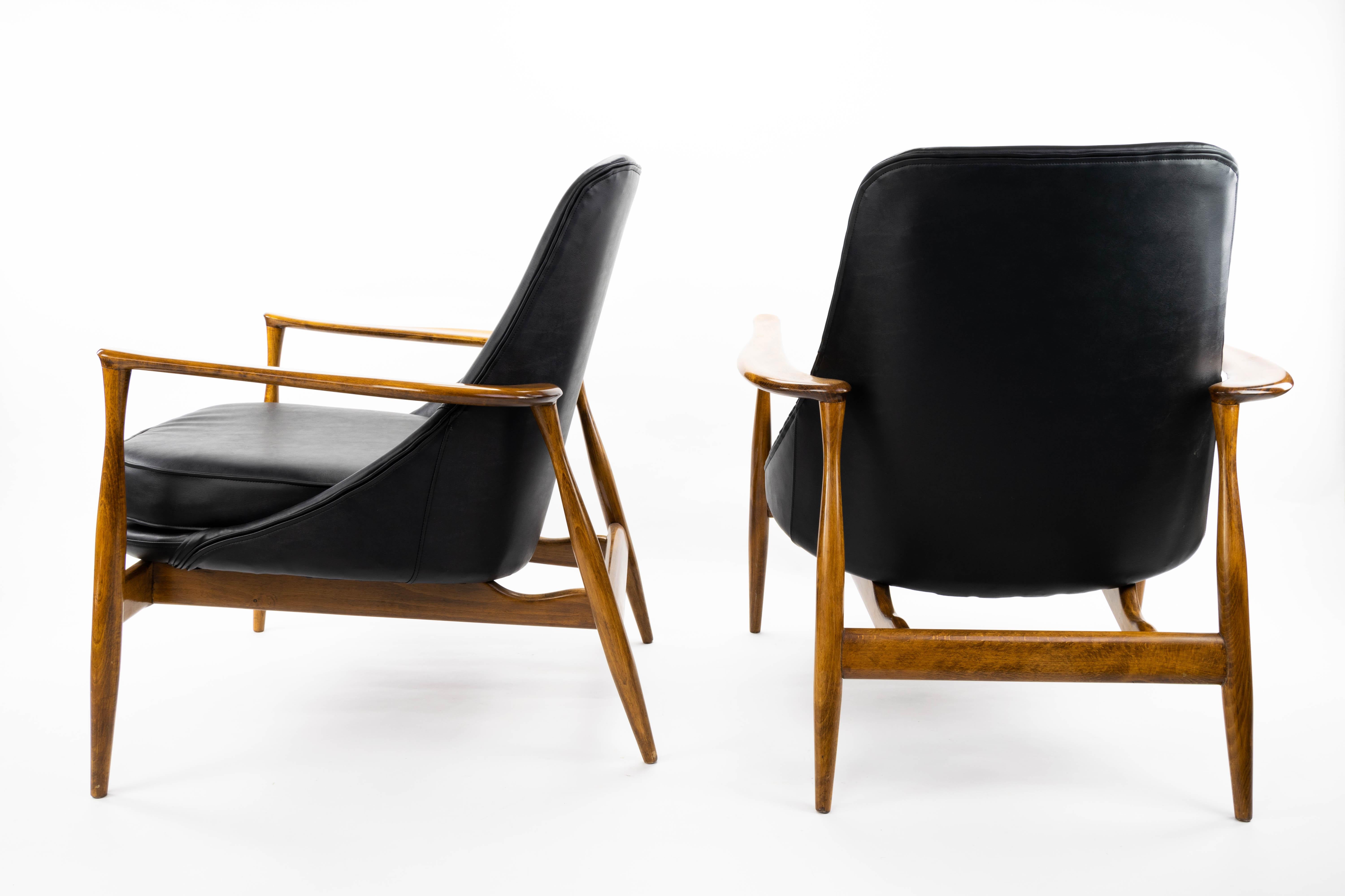 Danish armchairs designed by Ib Kofod Larsen  1956. Oak wooden structure recently restored and new upholstery in high-quality imitation leather.
Measurements:
Height 80 cm
Seat height 42 cm
High armrest 56.5 cm
Width 73 cm
Depth 73 cm.