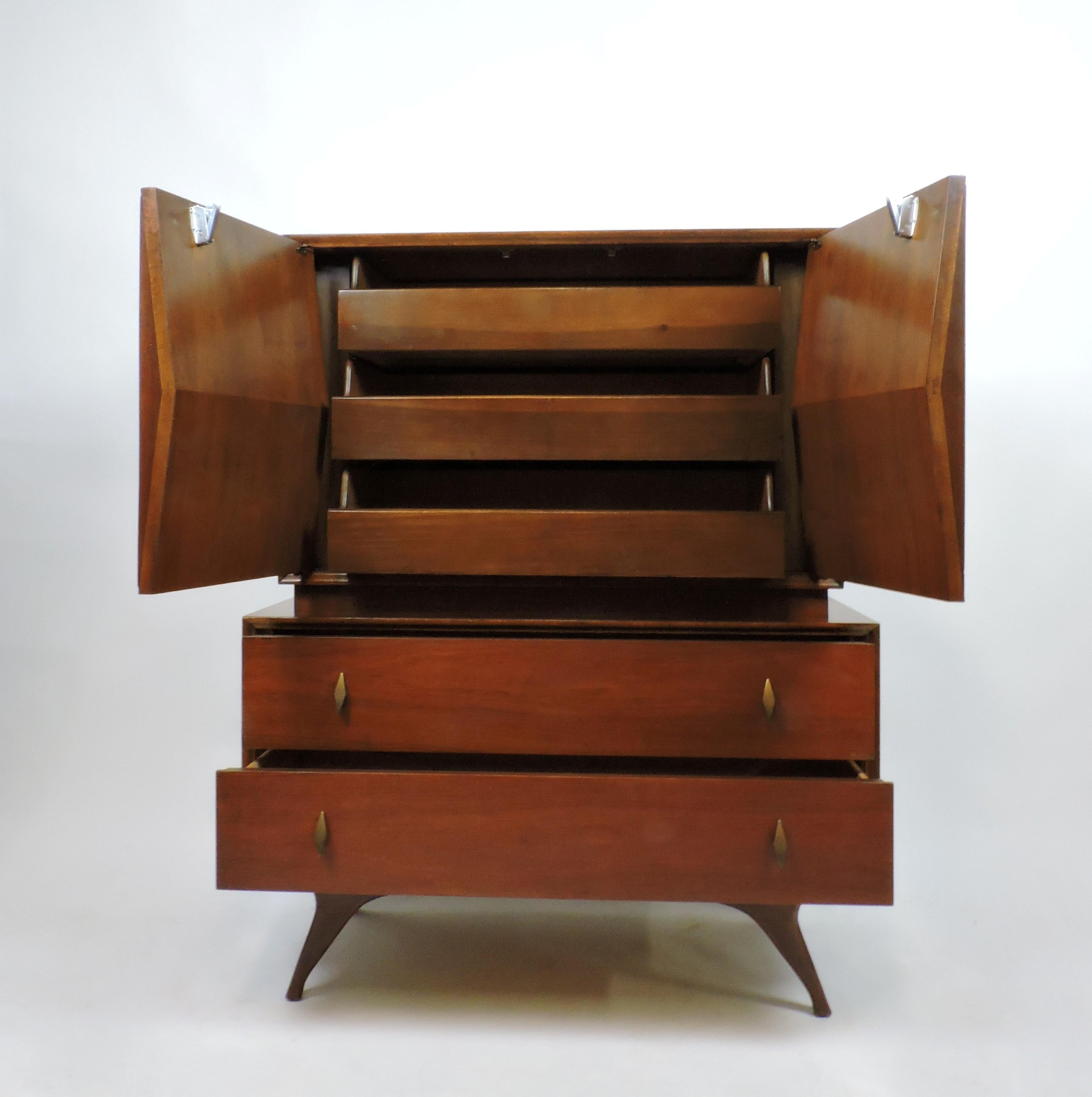 Very cool Albert Parvin walnut diamond front dresser. This cabinet has two push-to-open doors in a sculpted 3-dimensional diamond pattern behind which are three pull out drawers. Two additional drawers with brass diamond shaped pulls and graceful