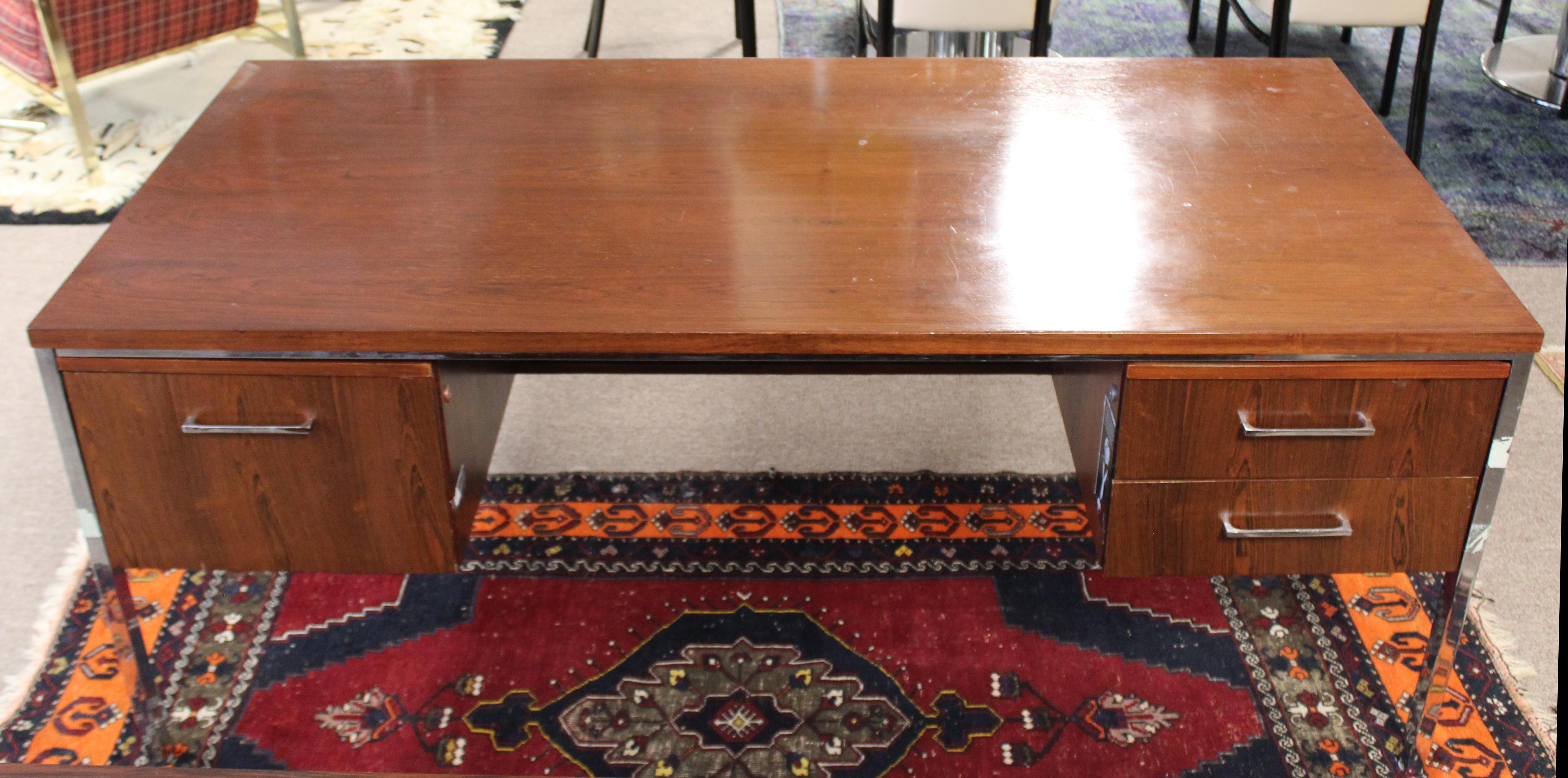 For your consideration is a delightful, executive desk, made of rosewood, with three drawers, including one for files, by Alma Desk Company, circa 1960s. In fair vintage condition. The dimensions are 72