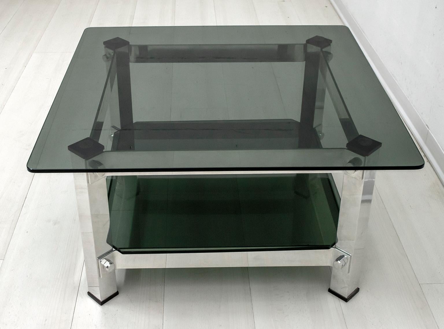 This coffee table was produced in Italy in the 1970s, certainly designed by a great design that we do not know who is among the many who created in that period. In aluminum and dark green glass, it has two shelves.

