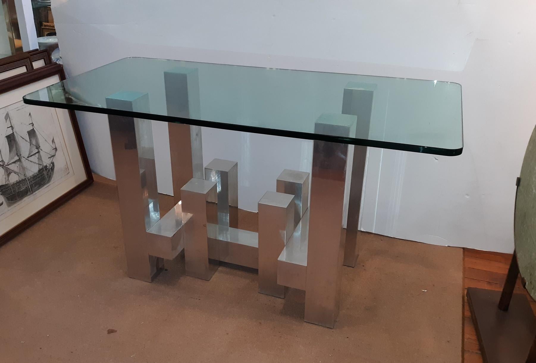 Chic and modern aluminum and thick glass table in the manner of Paul Evans. The 
