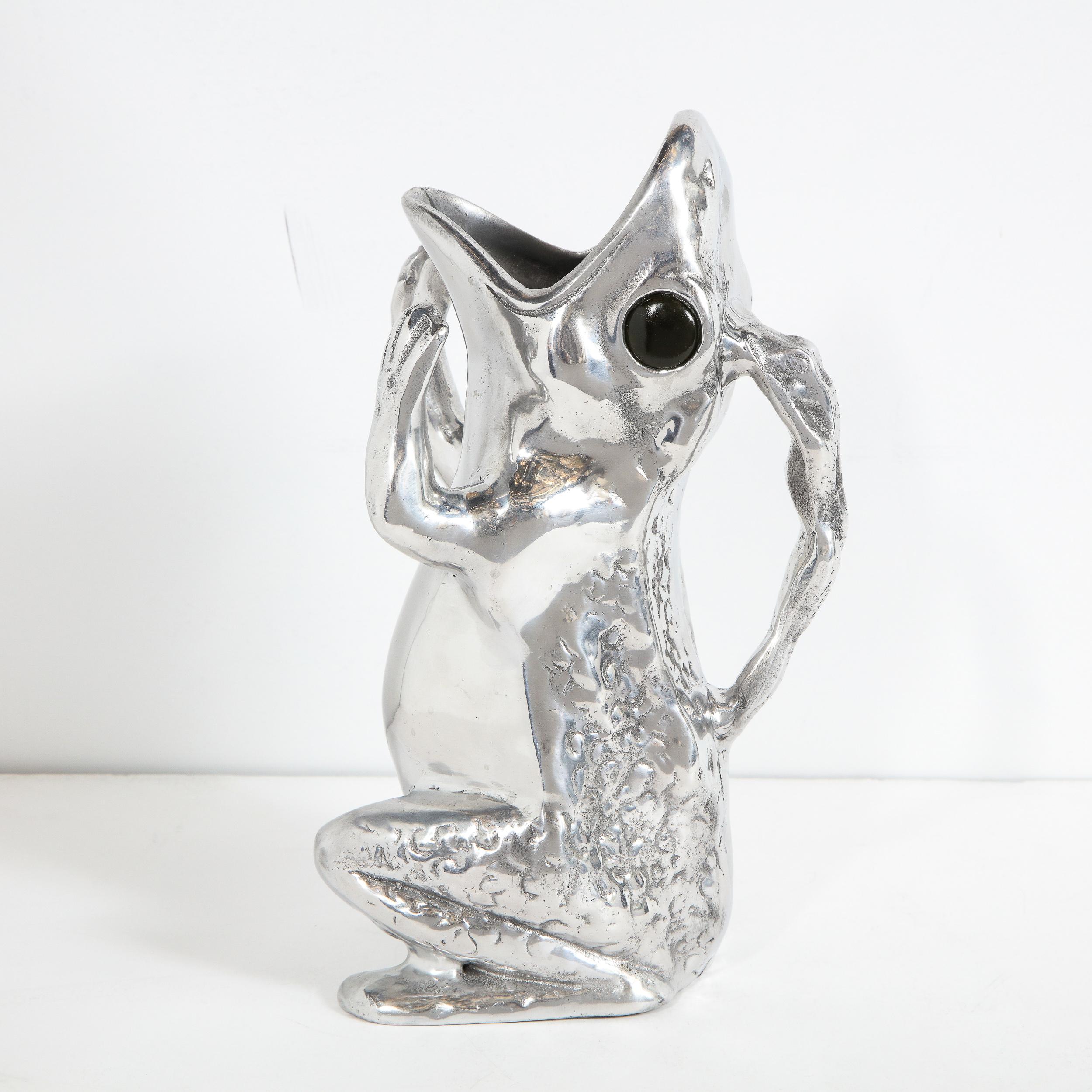 This sophisticated and whimsical frog pitcher was realized by the esteemed designer Arthur Court in the United States, circa 1979. It offers a kneeling frog with its mouth agape and its arms outstretched, depicted either in the midst of screaming