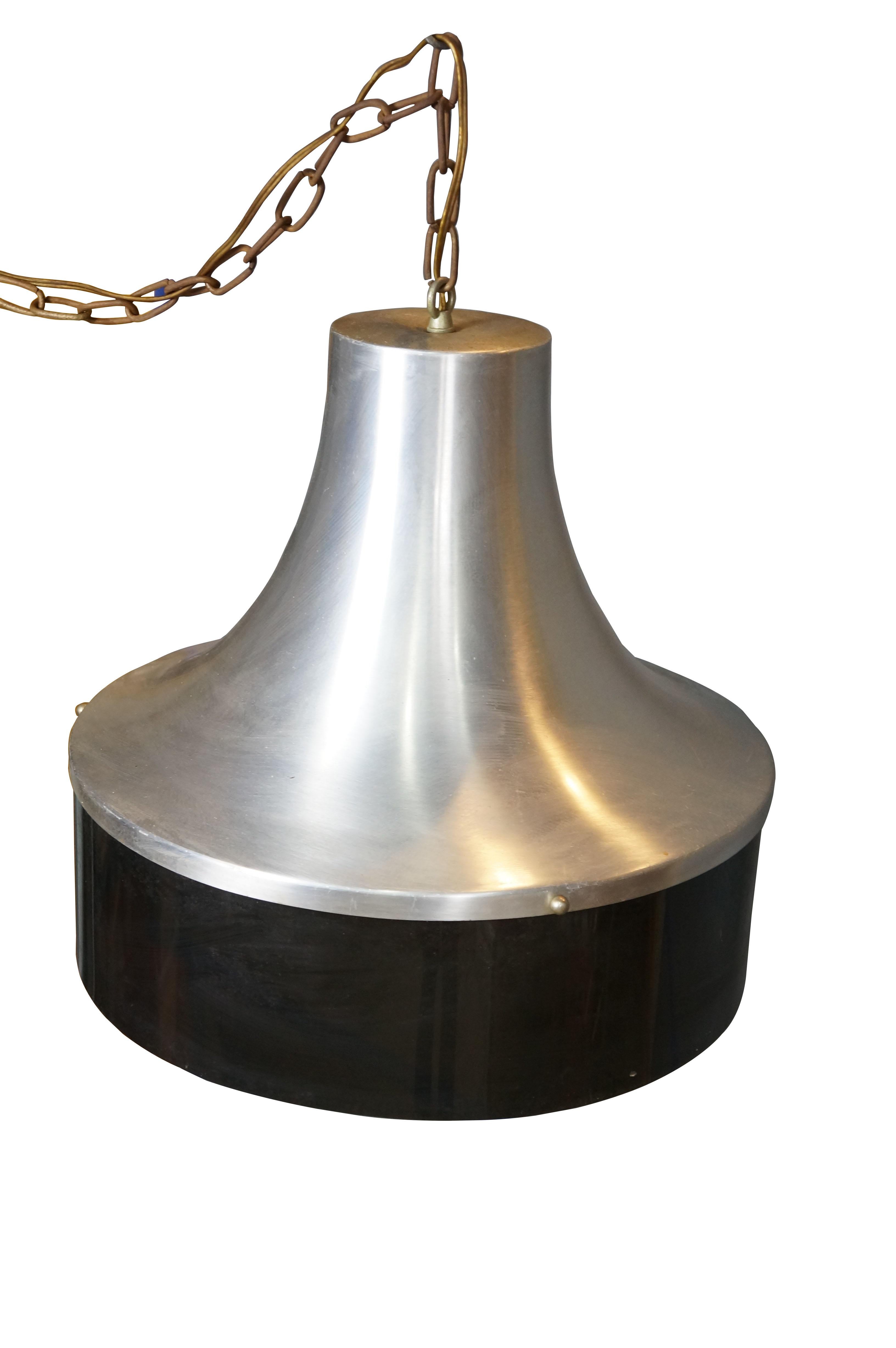 Pendente a forma di globo della metà del XX secolo. Piano in alluminio a forma di cappello con base in plastica marrone scuro, che nasconde un paralume in vetro lattiginoso. Include una catena. Spina.

Dimensioni:
16