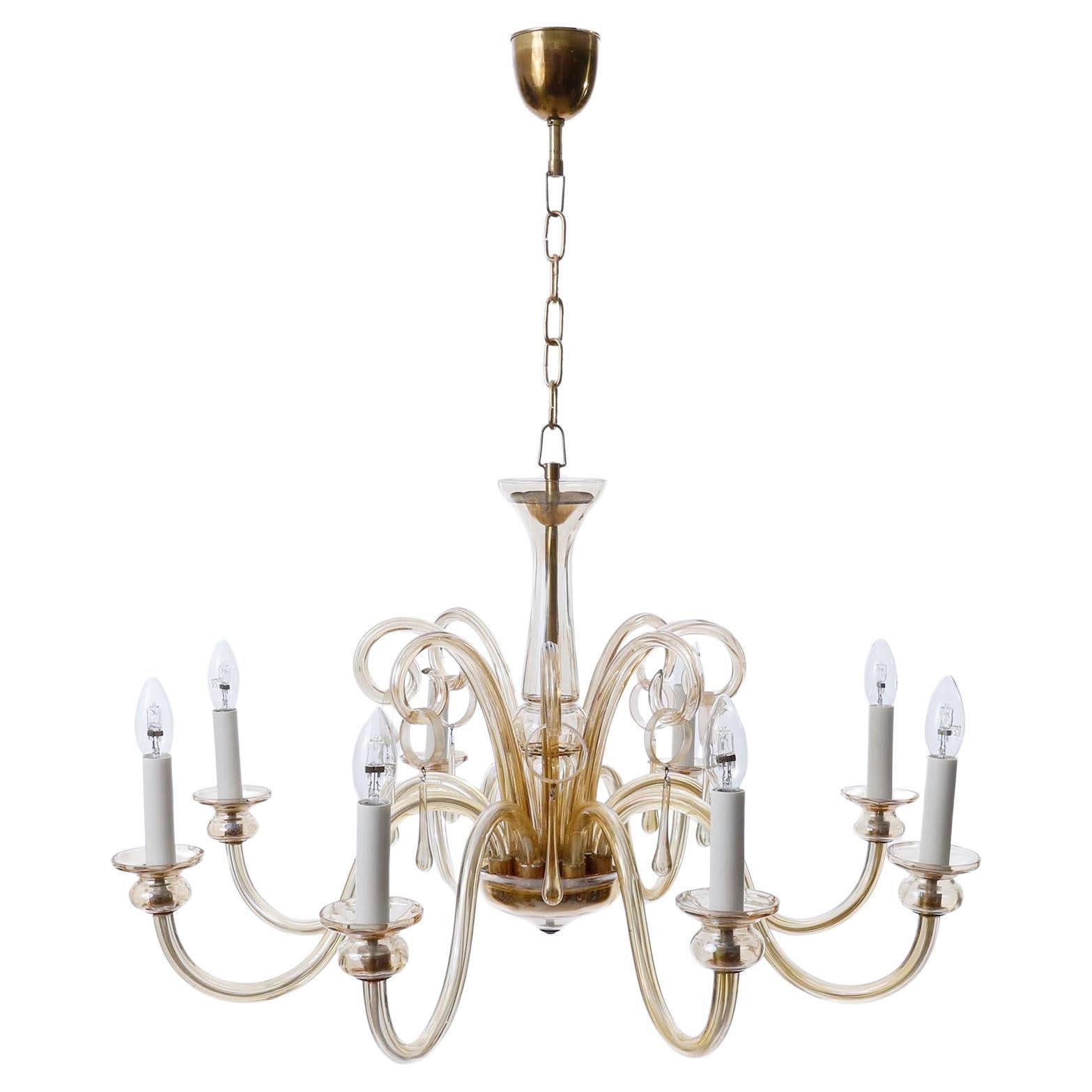 A large and beautiful eight-armed Art-Deco style Mid-Century Modern chandelier made of brass and mouth-blown amber Murano glass.
It is in very good condition and ready to use.
Measures: Height of body without chain: 18 inch (46 cm), current overall