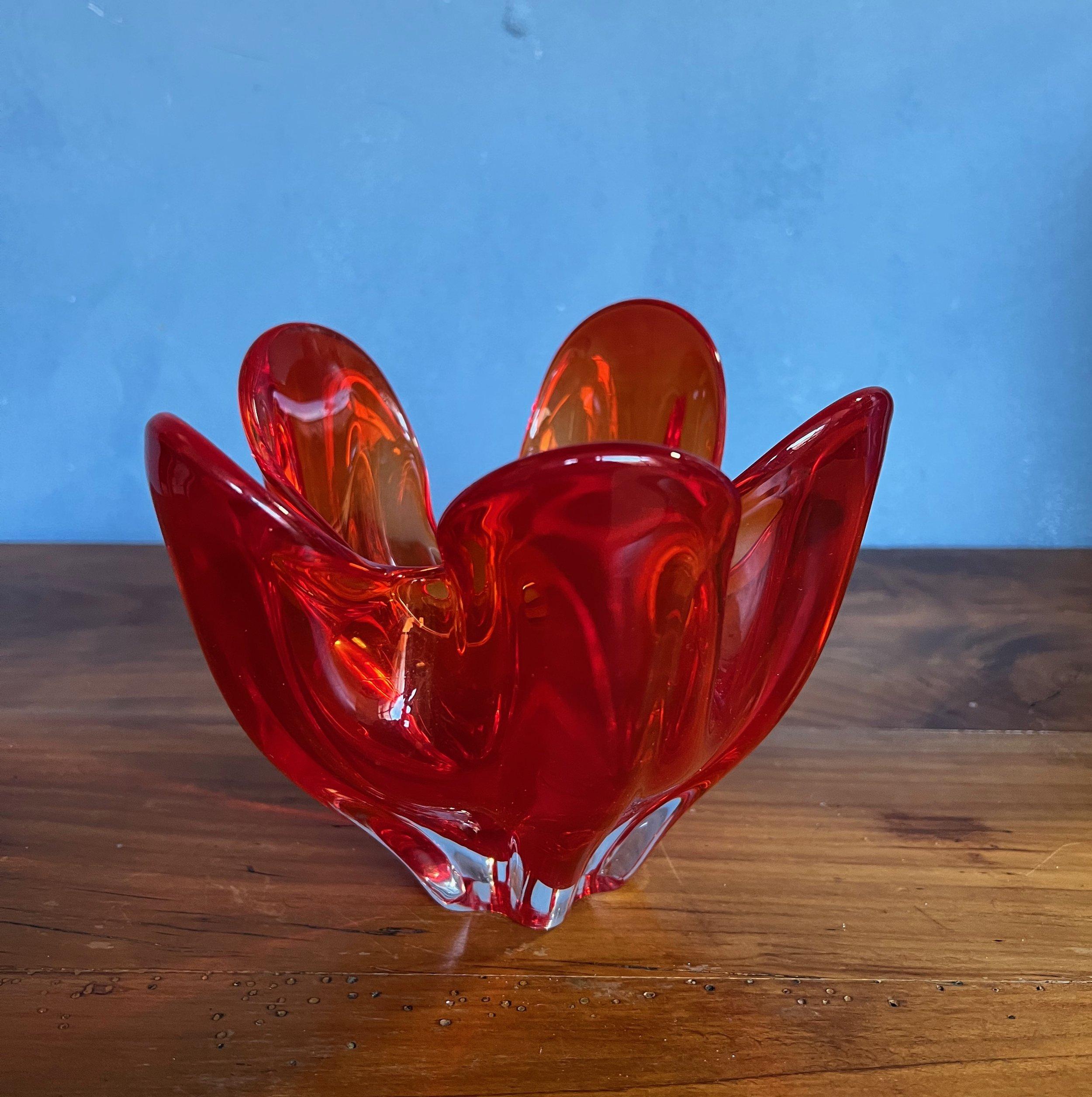 This appealing glass dish features an abstract petal-like design that captures the eye. Its rich color palette ranges from intense red to warm orange tones, creating an enchanting visual effect. The dish's distinctive style and quality suggest it
