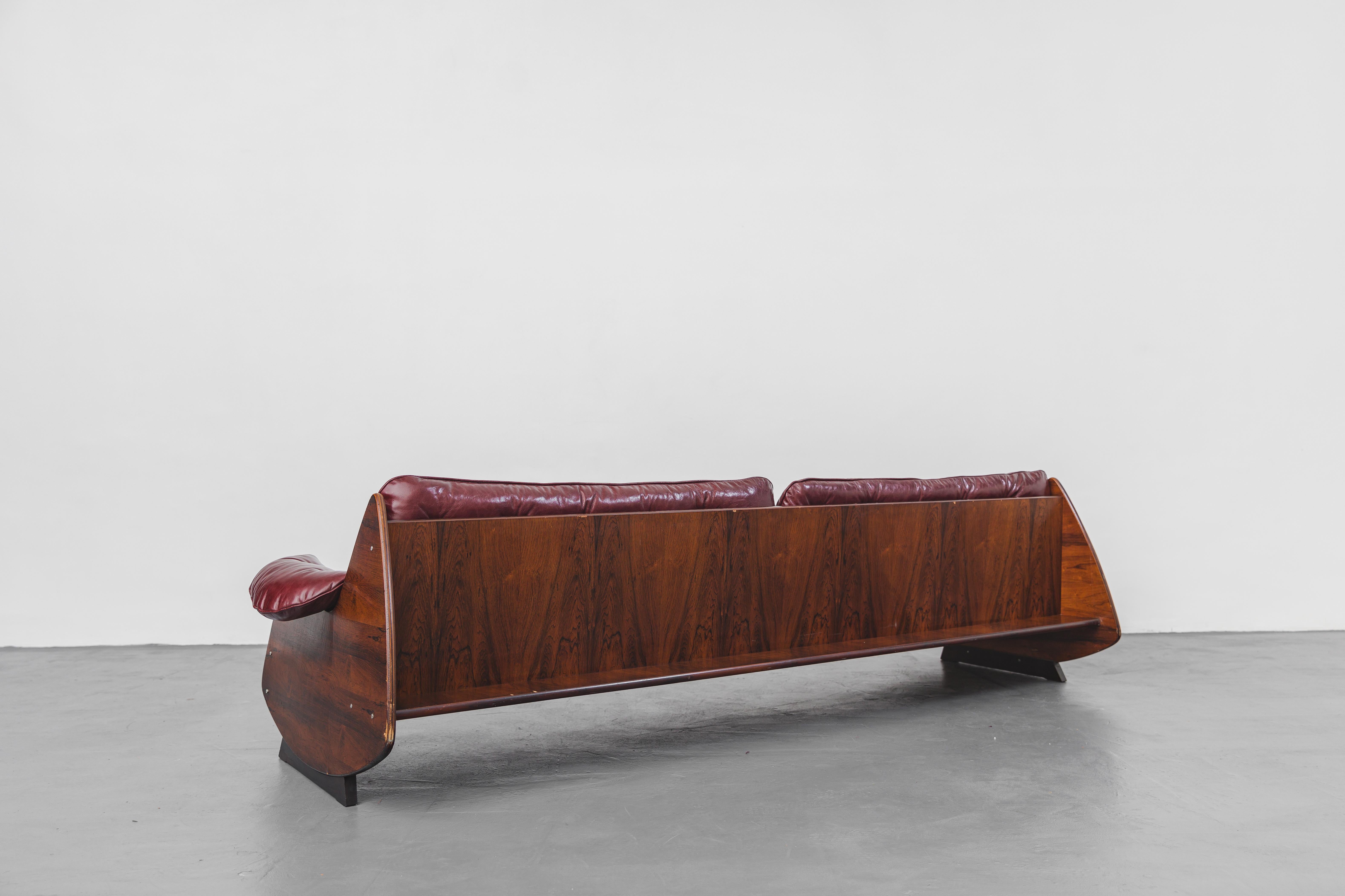 Das Ameba-Sofa wurde in den 1960er Jahren hergestellt und Jorge Zalszupin (1922-2020) zugeschrieben.

Das massive Sofa aus Palisanderfurnier ist eine perfekte Kombination aus organischen Formen mit übergroßen Lederkissen und Rückenfächern für kleine