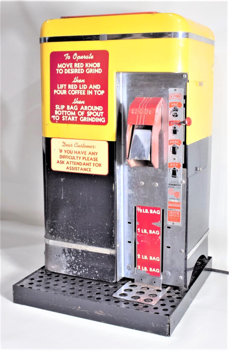 This commercial coffee grinder was made by the American Duplex Company of New York city in circa 1965 in the period Mid-Century Modern style. This is American Duplex's Grindmaster 500 model and is done in a bright yellow and contrasting black body