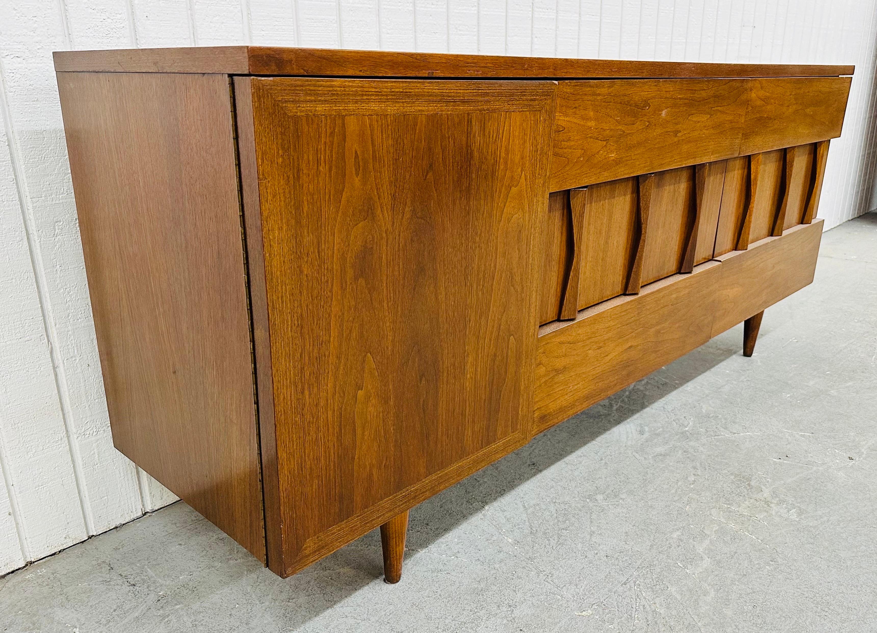 This listing is for a Mid-Century Modern American of Martinsville Dresser. Featuring a straight line design, brutalist front, door on the left that opens up to three hidden drawers, six larger drawers on the right side for storage, modern legs, and