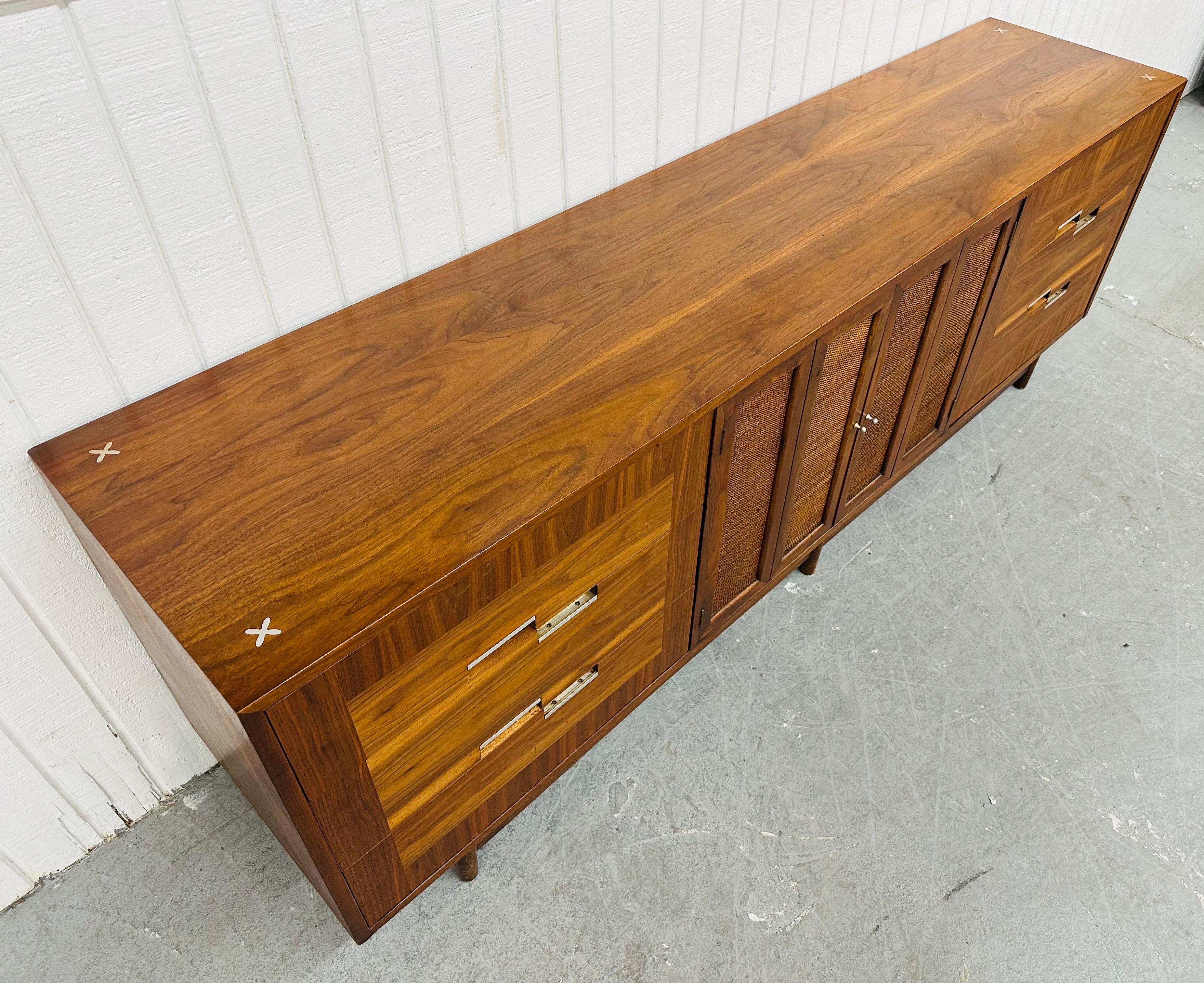 This listing is for a Mid-Century Modern American of Martinsville Accord Walnut Sideboard. Featuring a straight line design, six large drawers with chrome pulls, folding cane center doors that reveal three hidden drawers, modern legs, and a